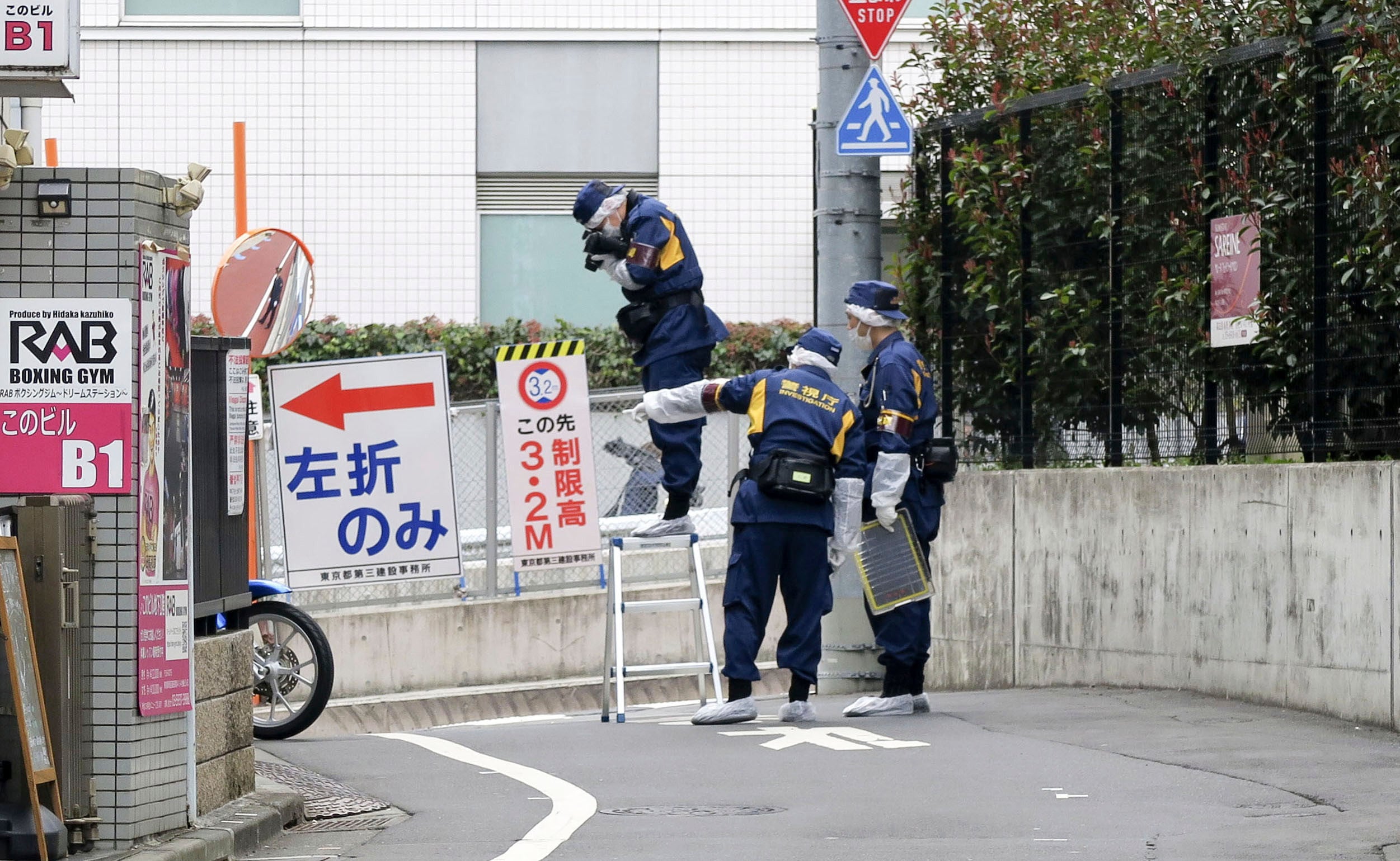 Japanese police investigators work near the scene of a stabbing of a woman in the Shinjuku district of Tokyo on March 11. Photo: Kyodo/AP