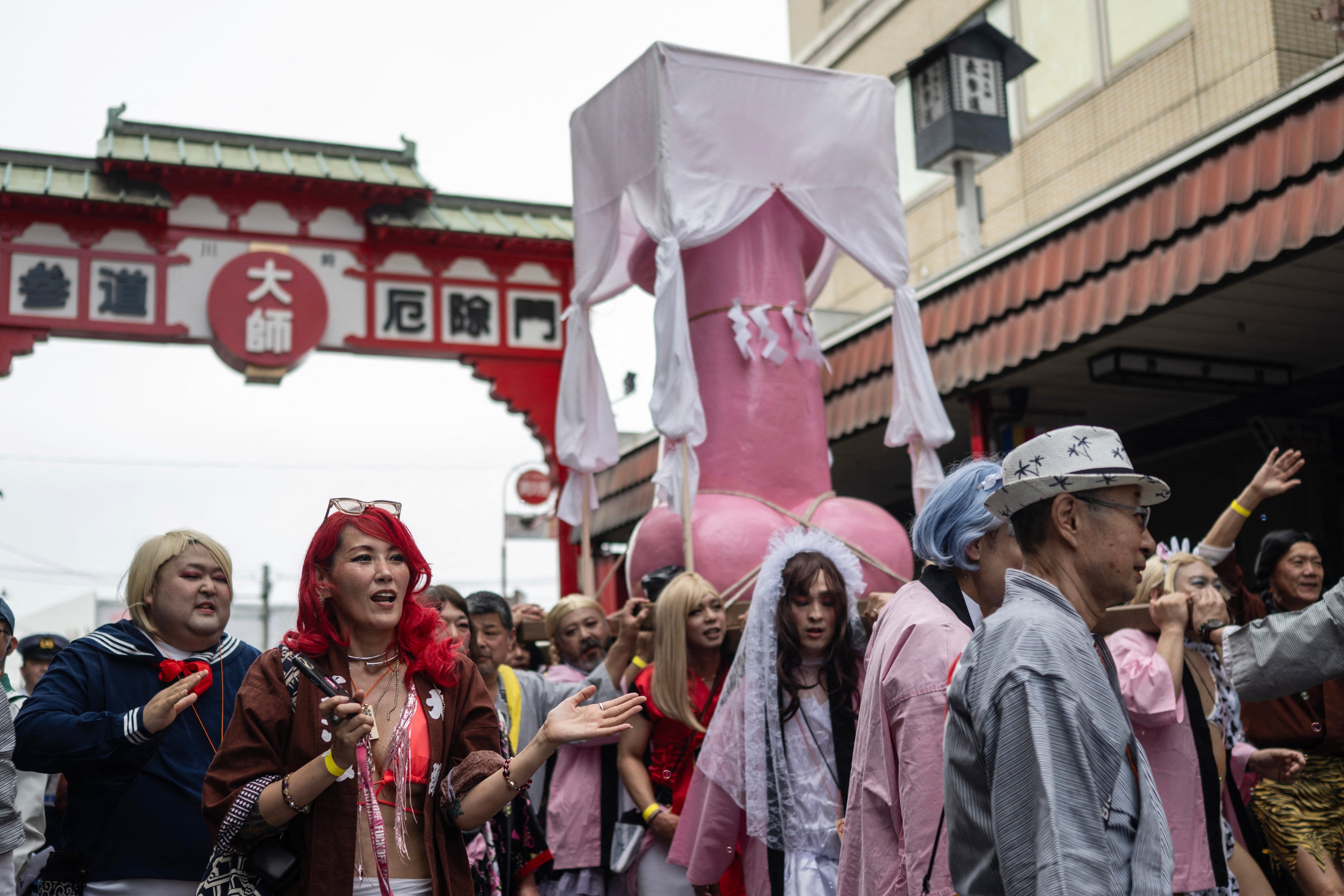 Devotees carry a large phallus-shaped portable shrine through the streets of Kawasaki during the Kanamara festival on April 5, 2026. Showcasing phallus-shaped portable shrines and pink penis candies, Japan’s annual fertility festival teemed April 5 with tourists, couples and families elated by its open display of sex. (Photo by Andrew CABALLERO-REYNOLDS / AFP)