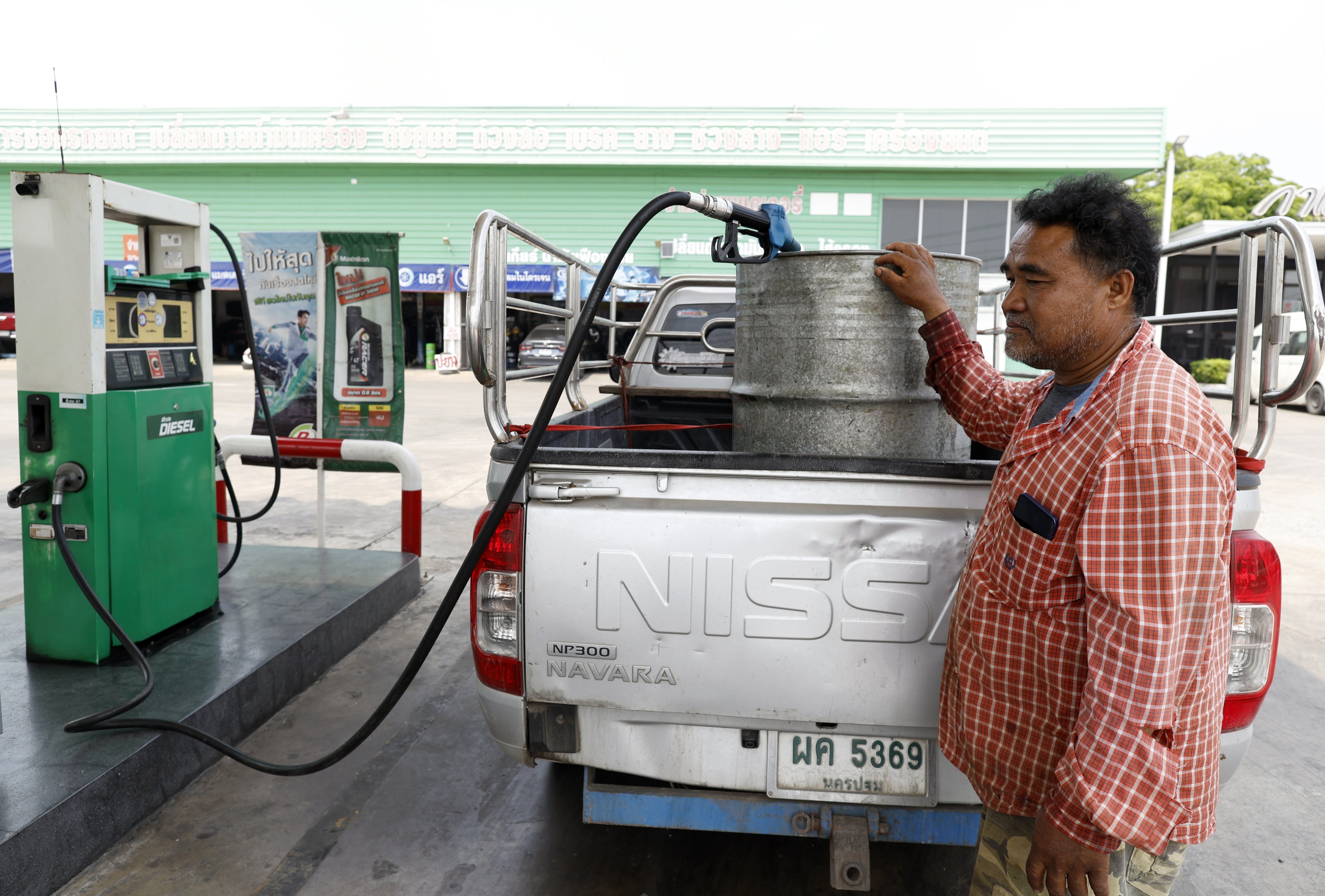 A Thai farmer refuels diesel into an oil drum at a gas station in Ayutthaya province on Wednesday. Thai farmers are struggling with shortages of diesel, fertiliser and insecticides amid the ongoing Iran war. Photo: EPA