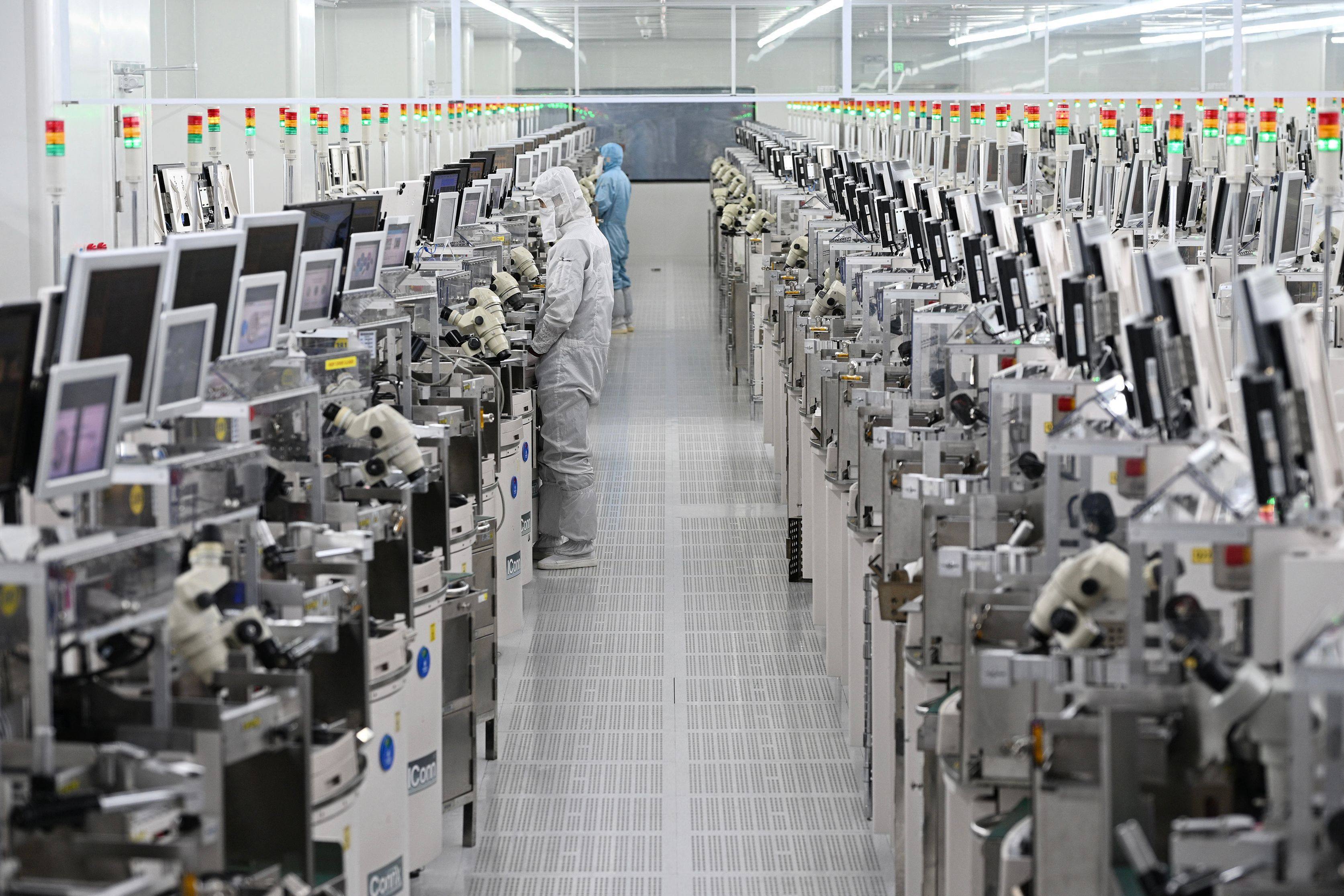 Technicians work on chip processing equipment at a semiconductor manufacturing plant in Suqian, 
Jiangsu province, in October. Photo: AFP