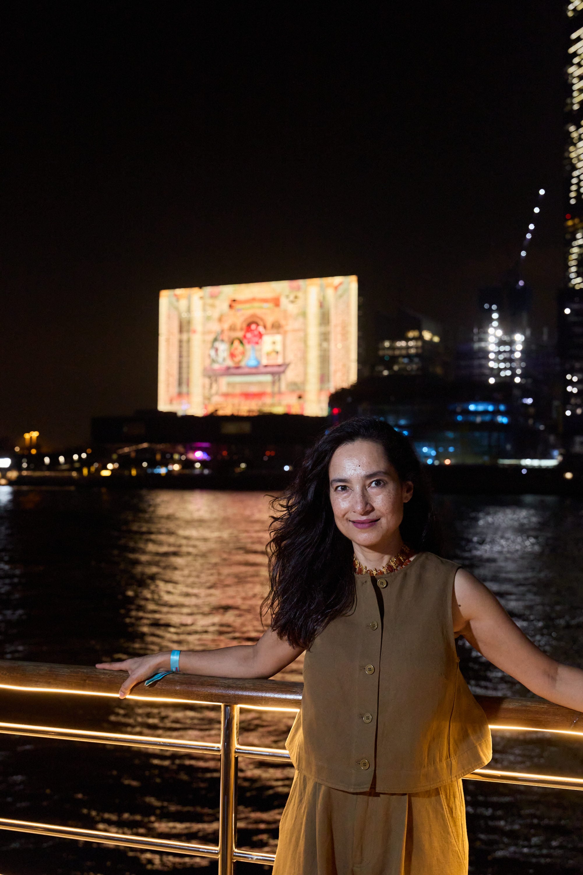 Shahzia Sikander stands in front of her work “3 to 12 Nautical Miles” (2026) playing on the giant TV screen on the M+ museum facade. The video will be shown every night until June 21. Photo: Winnie Yeung/Visual Voices