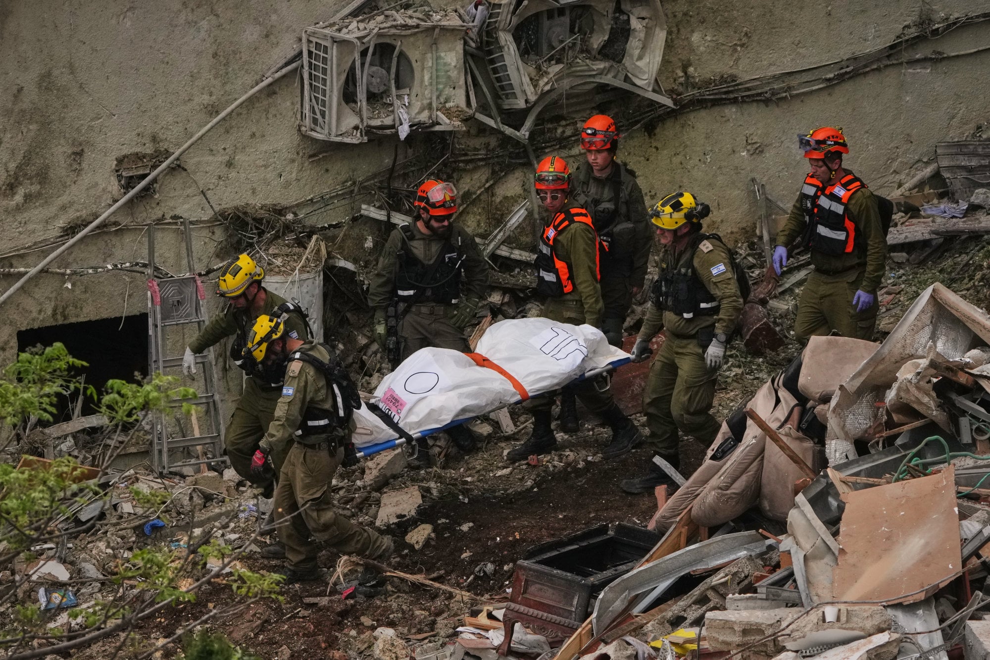 Rescuers and military personnel in Haifa, Israel, carry a body from the rubble of a residential building after it was struck by an Iranian missile. Photo: AP