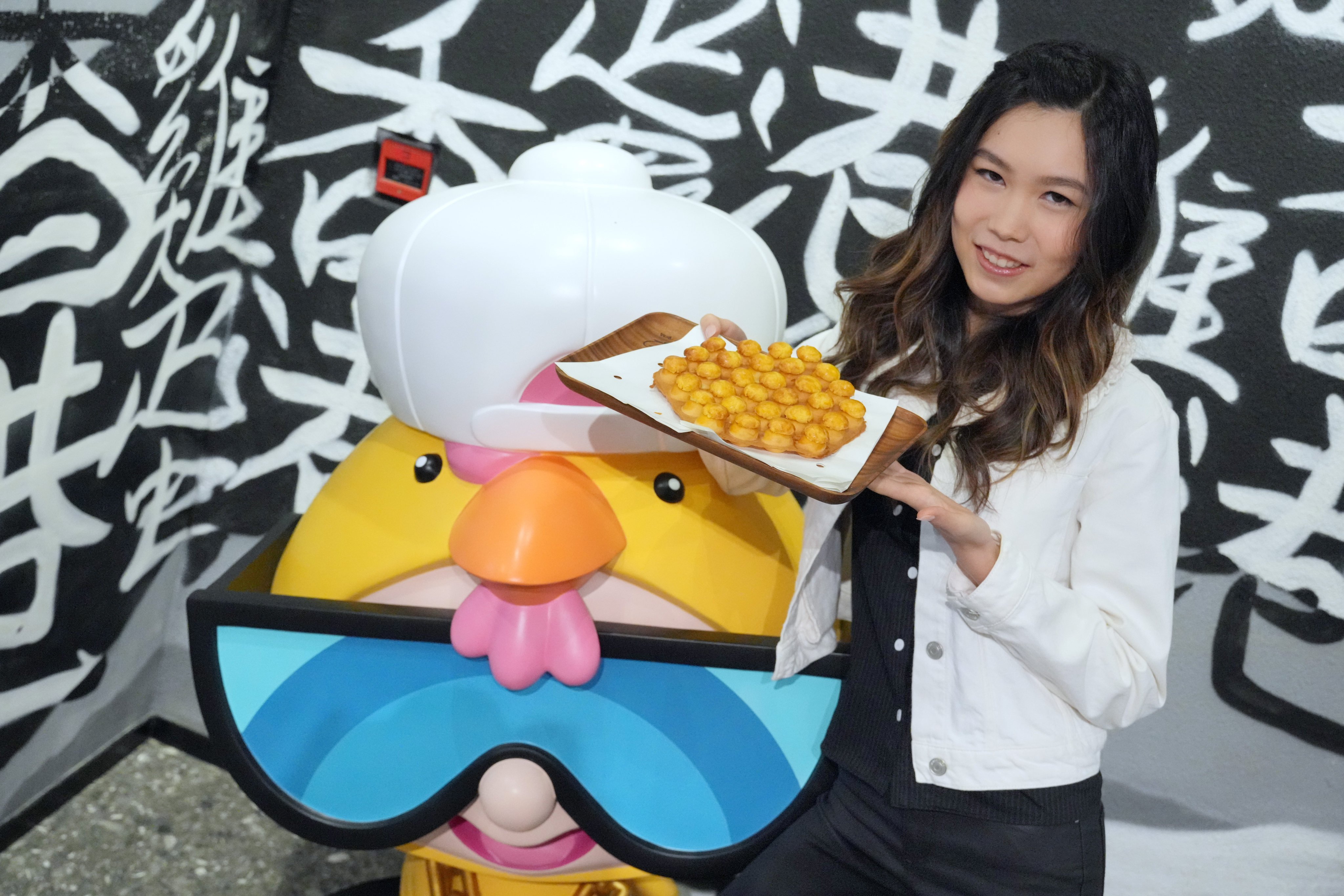 Chicken Egg Boy founder Natalie Lau holds up one of her pineapple bun egg waffle creations at her shop in Sheung Wan. She reveals her favourite Hong Kong restaurants for dim sum, fusion food, snacks and more. Photo: May Tse