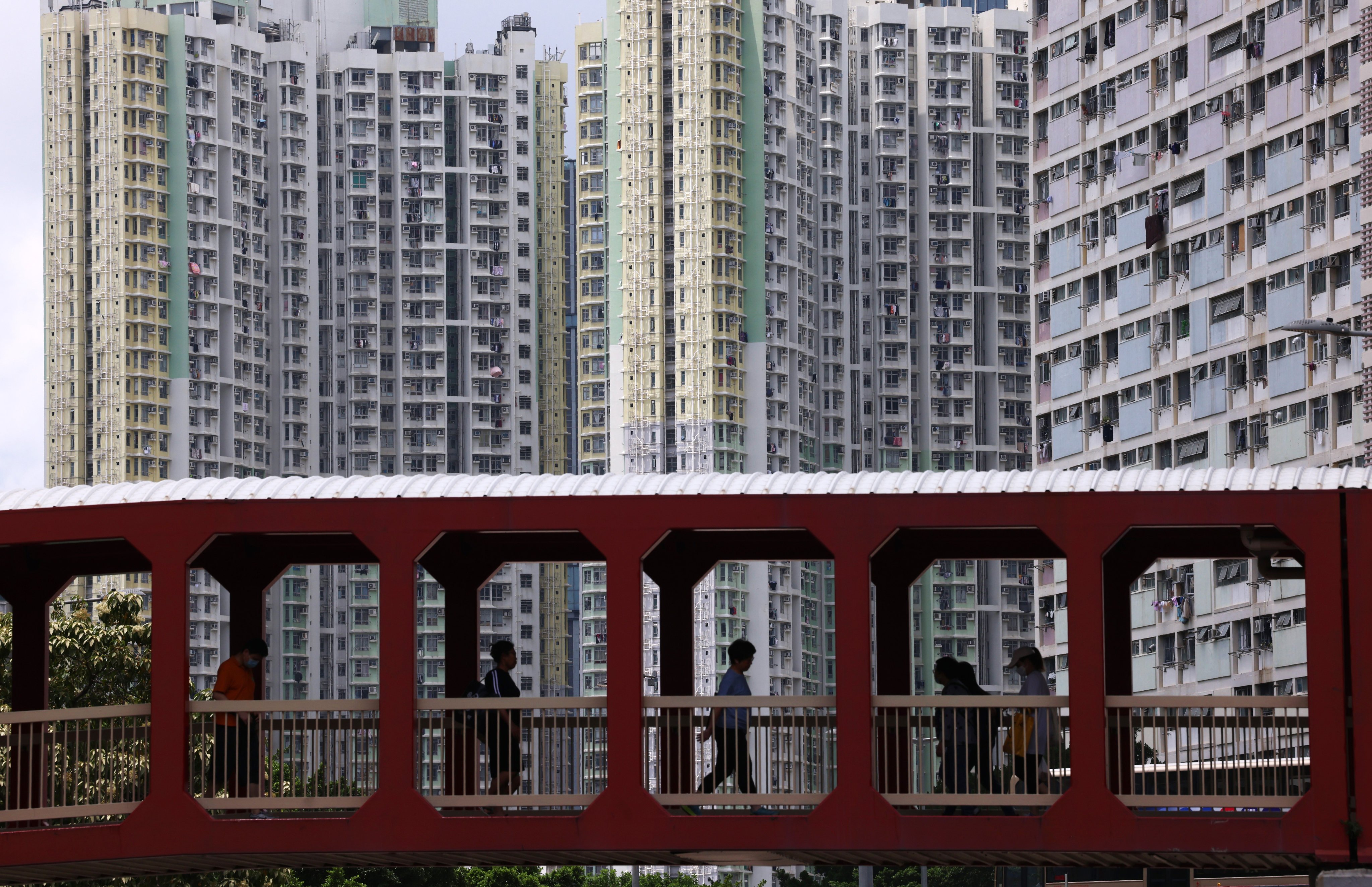 People walk across a bridge, with Kai Ching Estate and Choi Hung Estate in the background, in 2025. A public health approach ought to be taken to mental health crisis intervention by integrating police with academia and NGOs. Photo: Jelly Tse