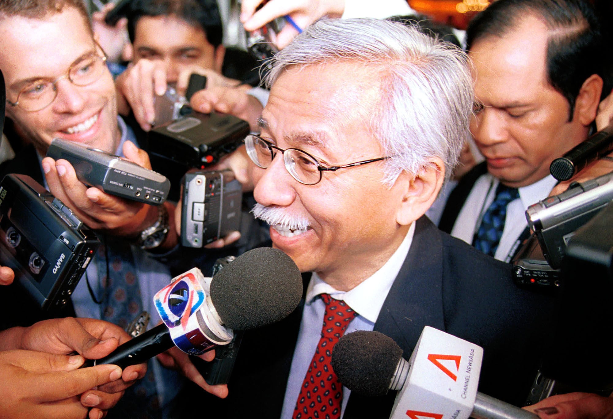 Malaysia’s then-finance minister Daim Zainuddin is surrounded by reporters after delivering a speech to the Asia Pacific Group on Money Laundering in Kuala Lumpur on May 22, 2001. Photo: AP