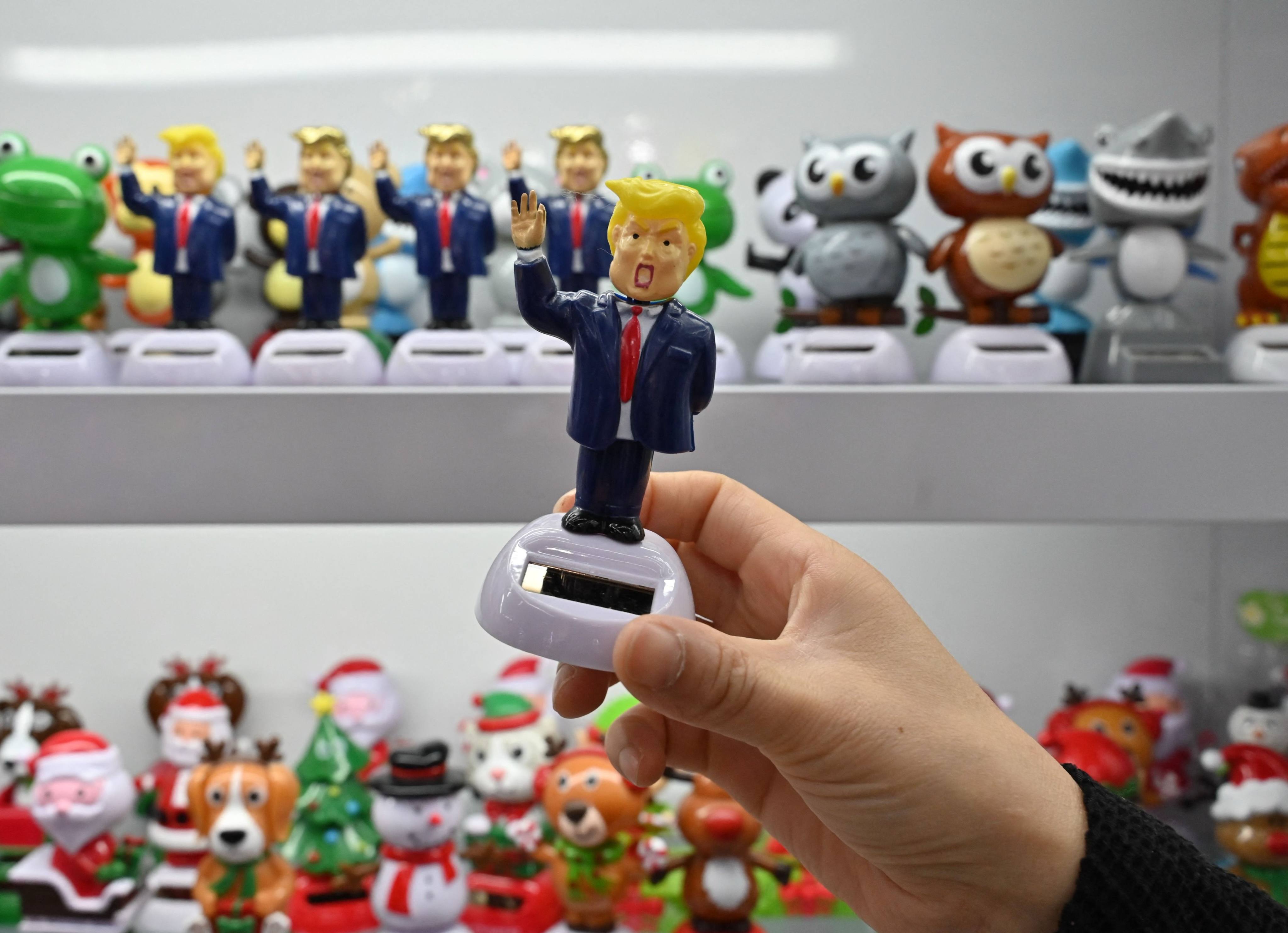 A shop owner holds a toy depicting US President Donald Trump at the Yiwu International Trade Market in Yiwu, Zhejiang province on April 10, 2025. Photo: AFP