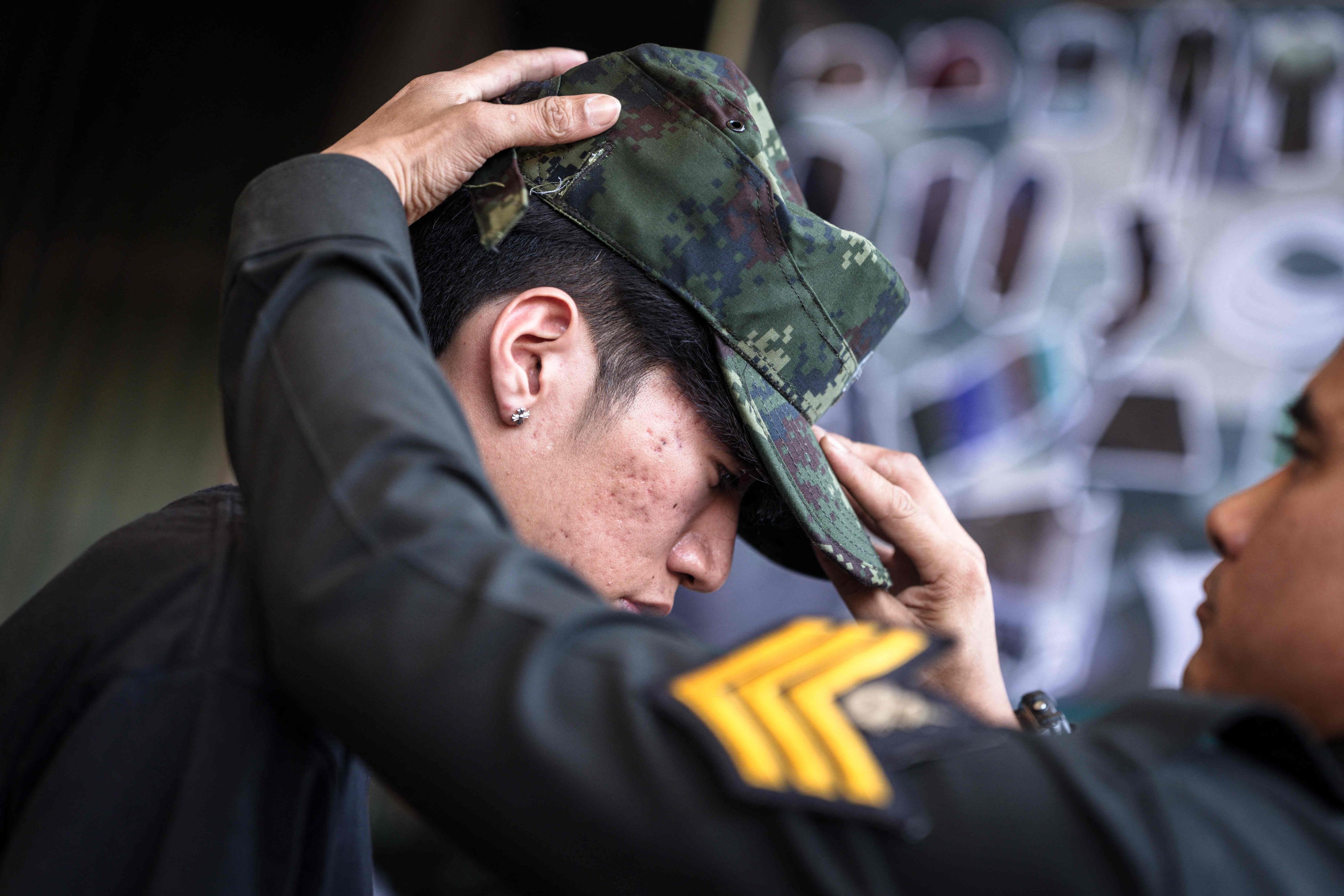 A soldier puts a hat on an enlisted man during the Thai military conscription drawing in Bangkok on Tuesday. Photo: AFP