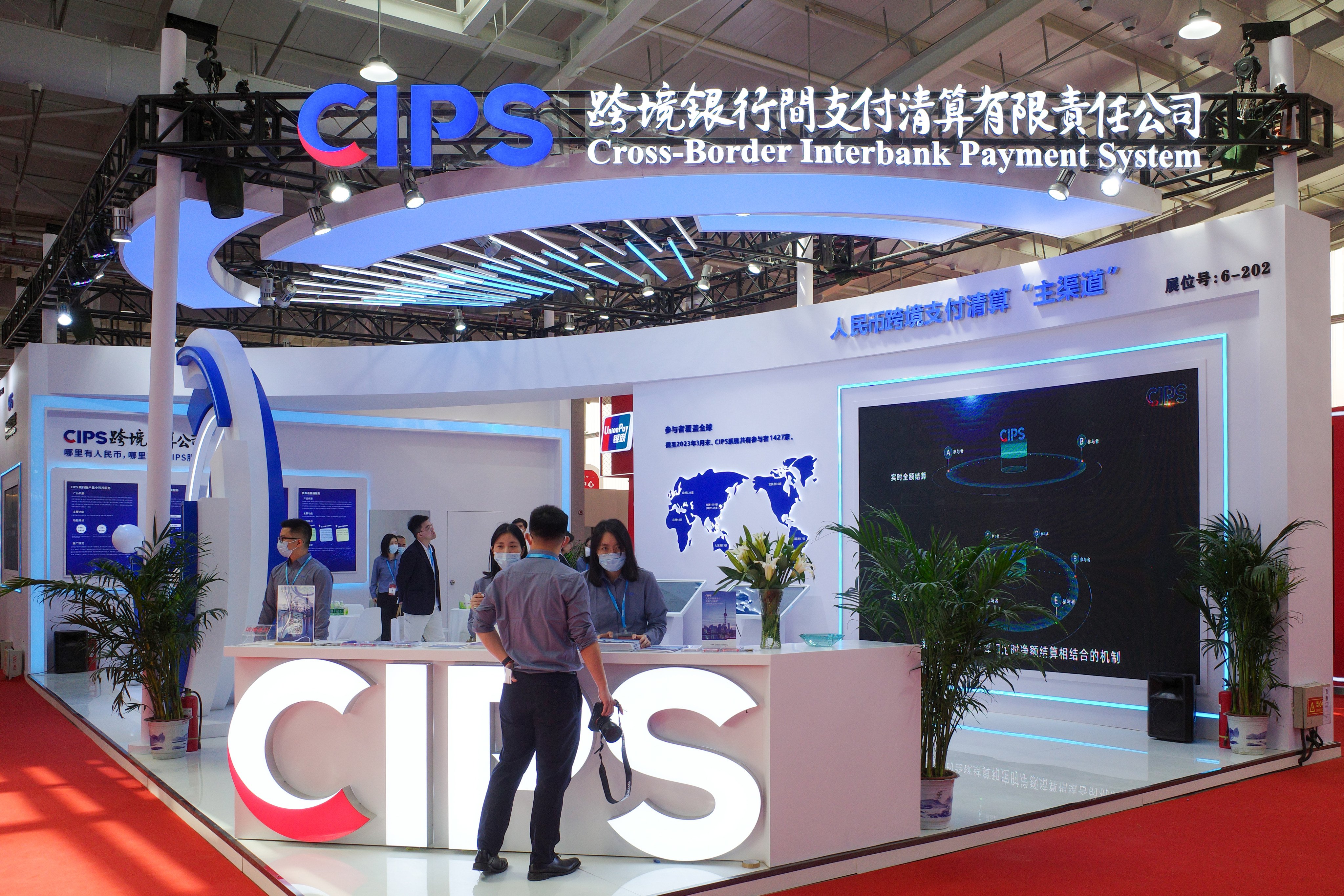 People are seen at a booth promoting China’s Cross-Border Interbank Payment System during a financial exhibition in Beijing. Photo: Getty Images