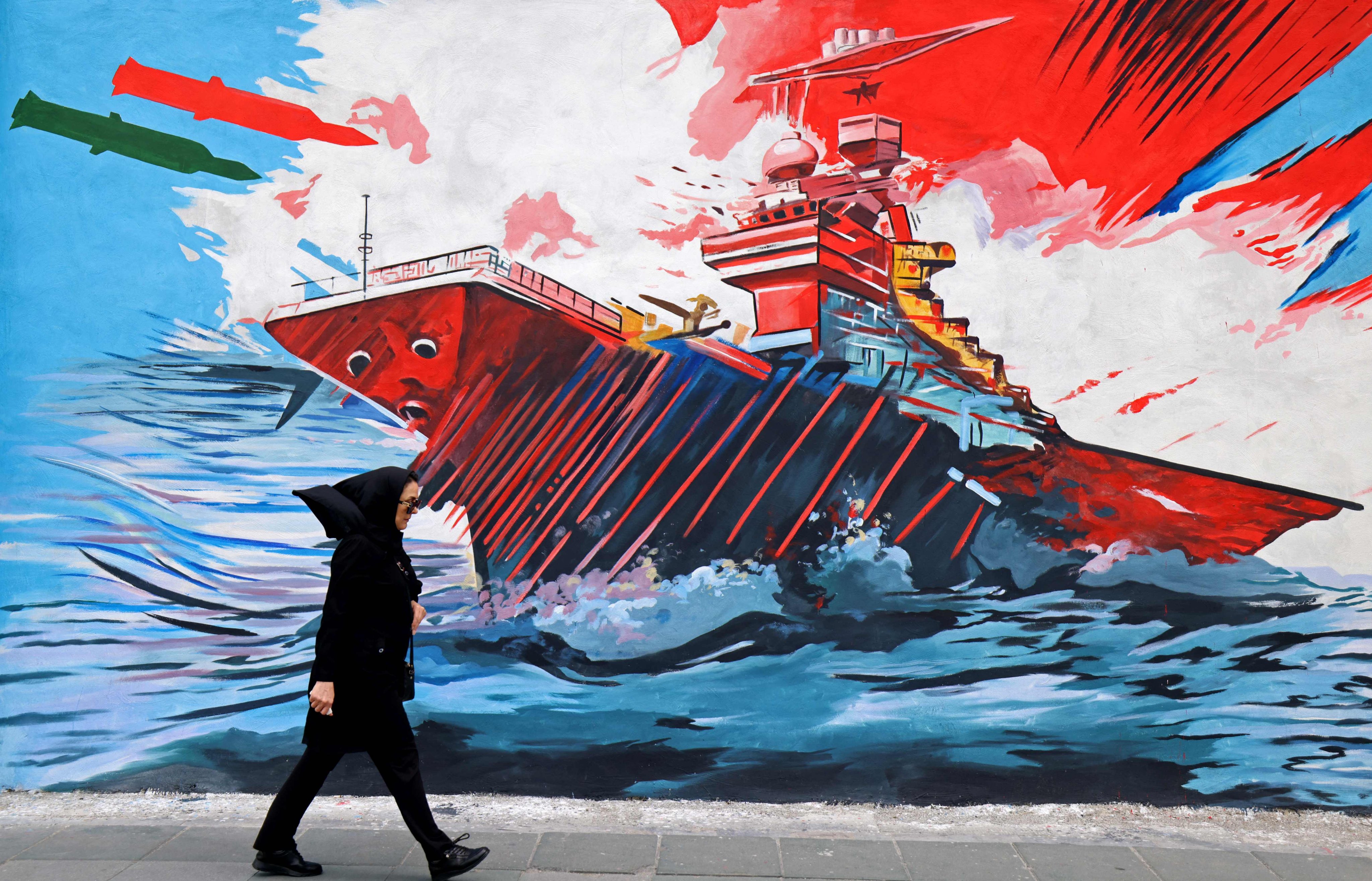 A woman walks past an anti-US and anti-Israel mural, in Tehran on April 8, 2026. Photo: AFP