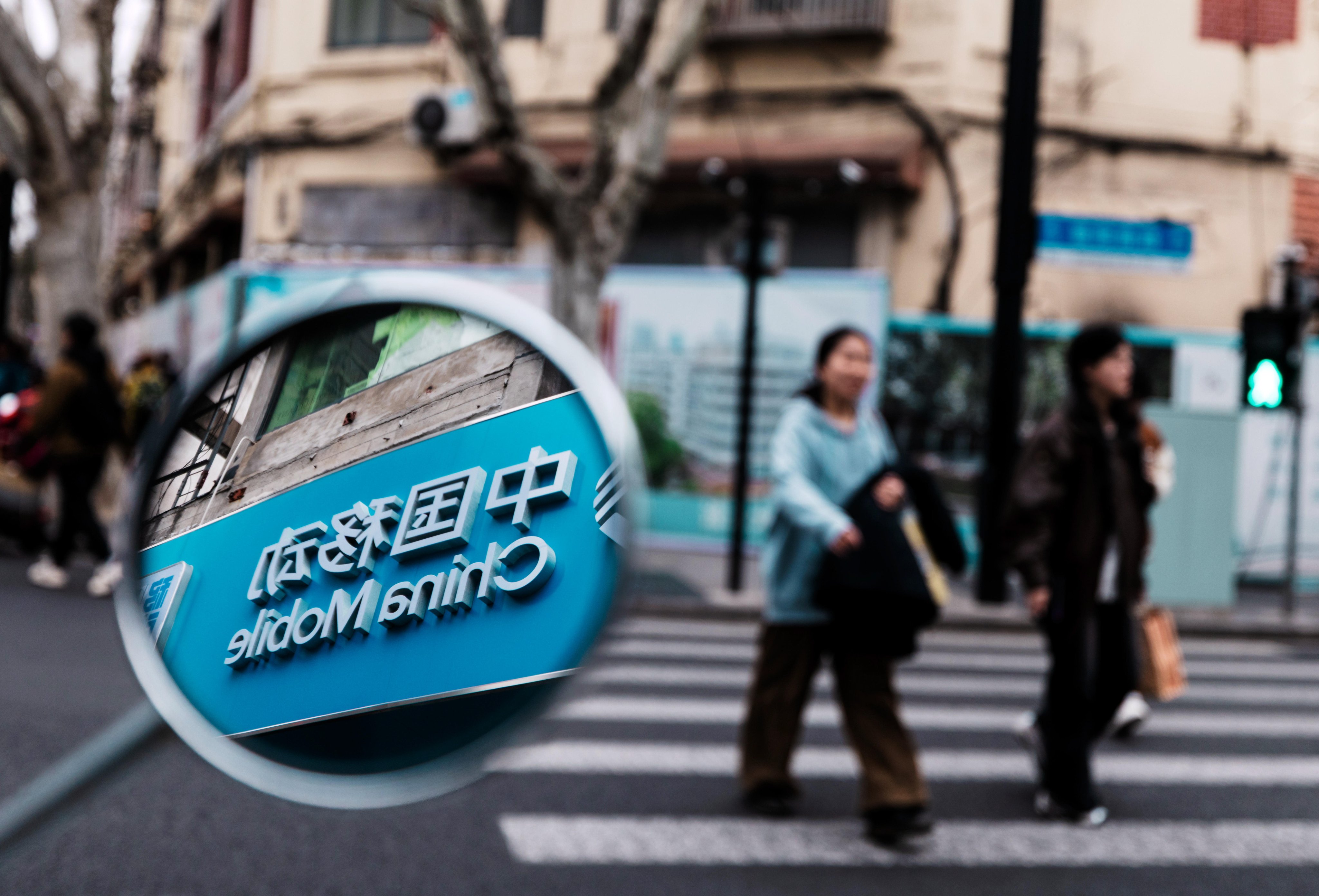 A China Mobile logo is seen in a mirror in Shanghai on March 26, 2026. Photo: EPA