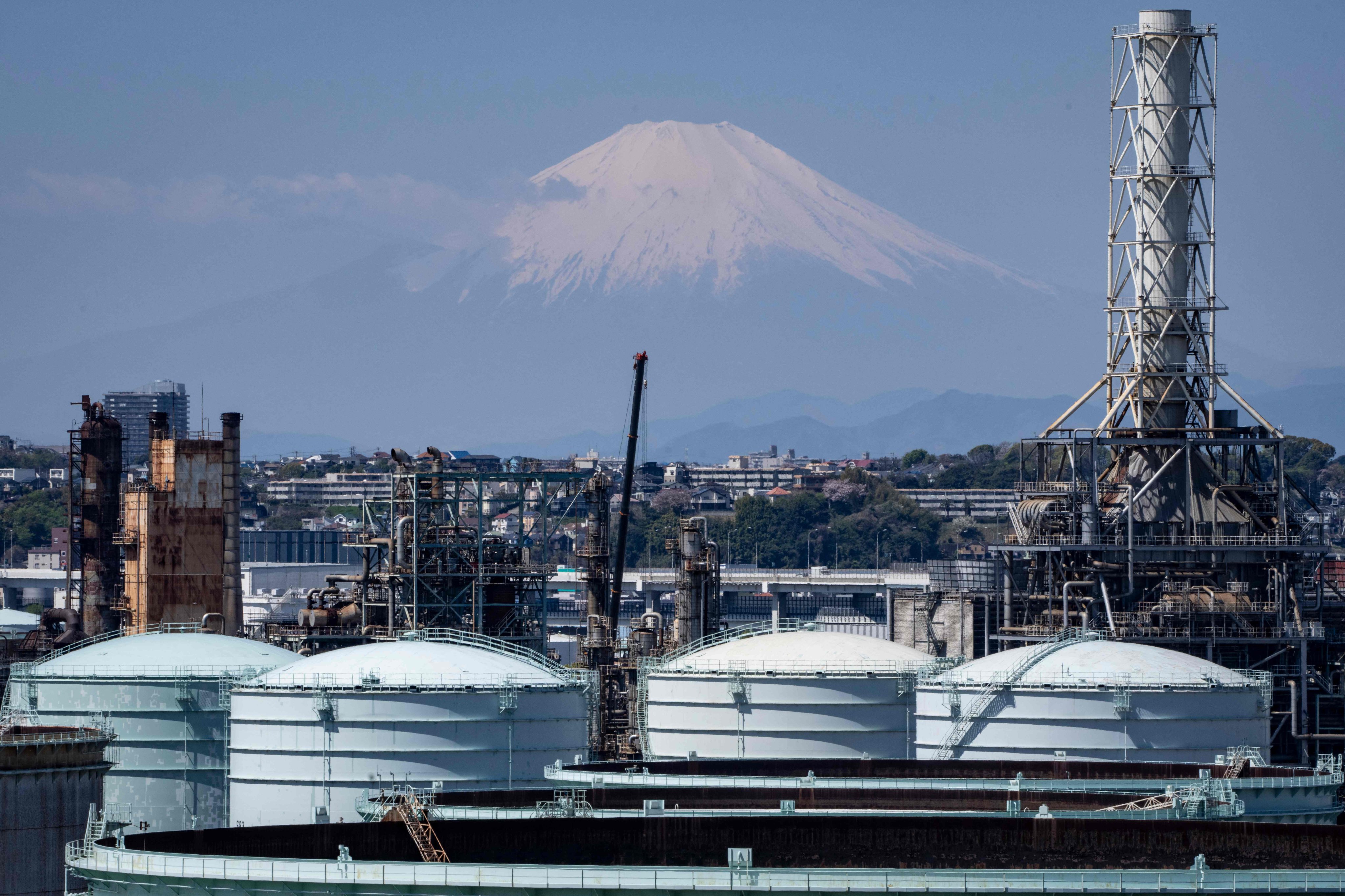 Storage tanks are seen at an oil refinery in Yokohama, Japan’s Kanagawa prefecture, as Mount Fuji looms in the background. Photo: AFP
