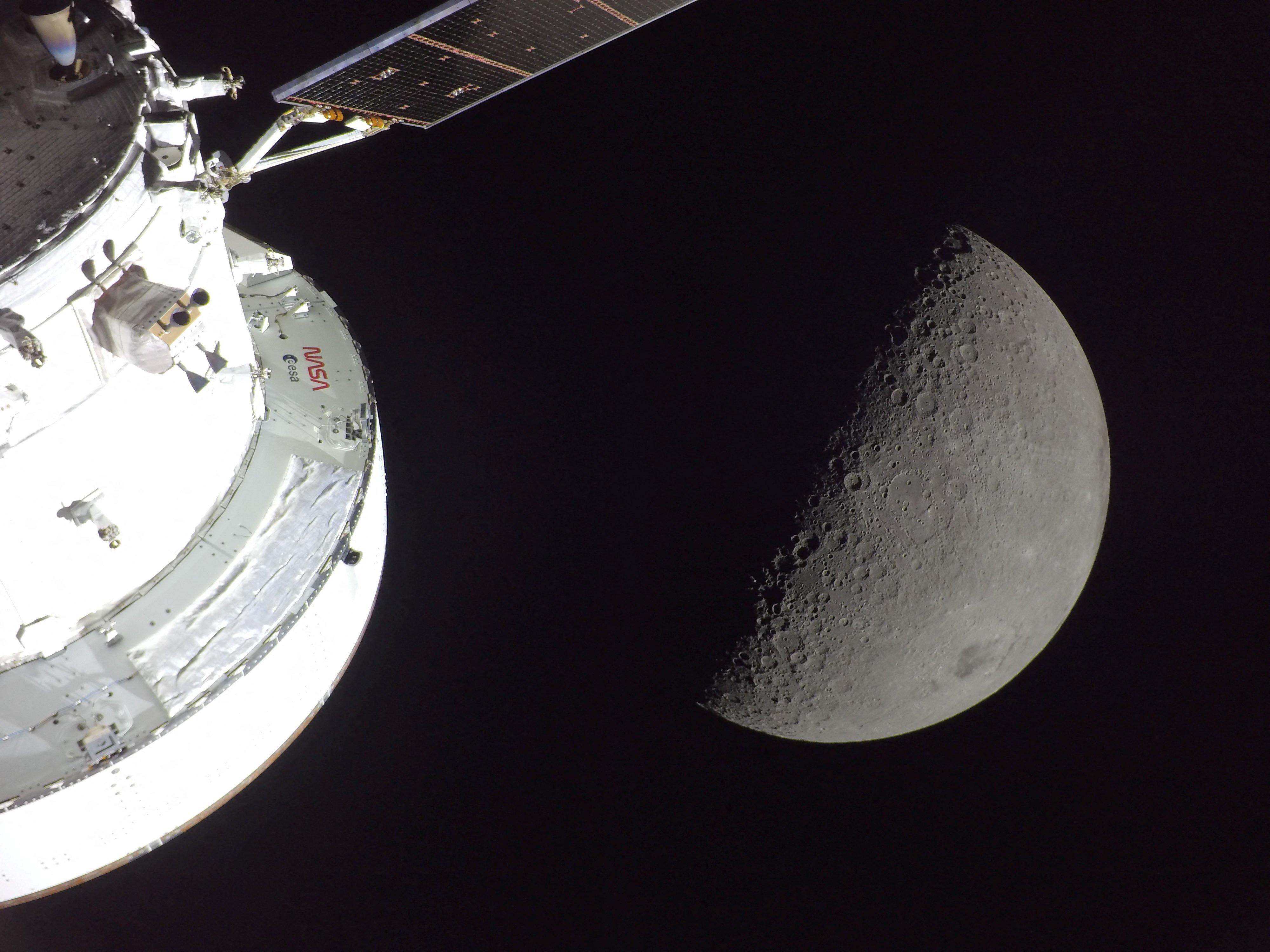 A view of NASA's Orion spacecraft in the foreground, lit up by the Sun, as a first-quarter Moon is visible behind it as photographed by one of the cameras on the Orion spacecraft's solar arrays during the Artemis II crew's flyby of the Moon April 6, 2026. According to the image file data the picture was taken with a GoPro HERO4 Black camera.   NASA/Handout via REUTERS
THIS IMAGE HAS BEEN SUPPLIED BY A THIRD PARTY
