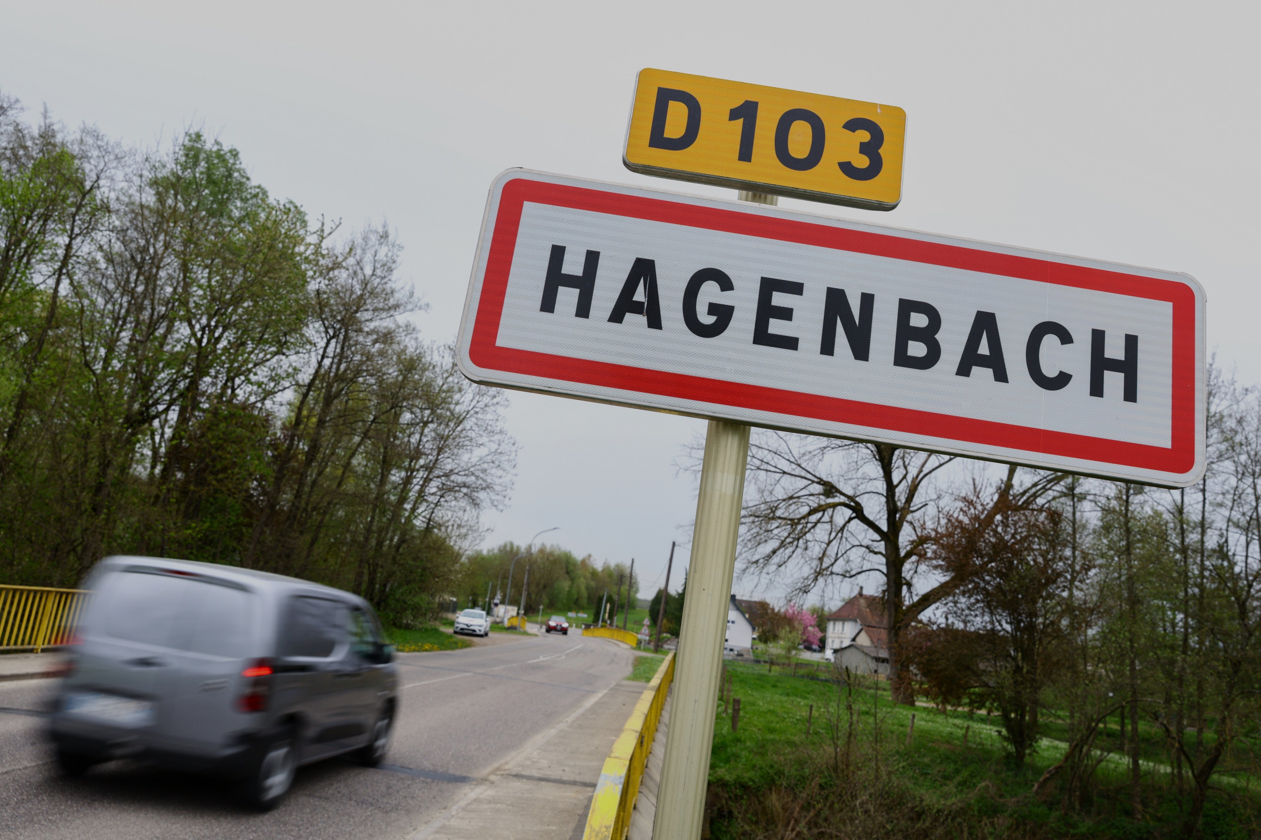 A car drives past a road sign at the entrance to Hagenbach, France, where a boy was rescued this week from his father’s van. Photo: AP