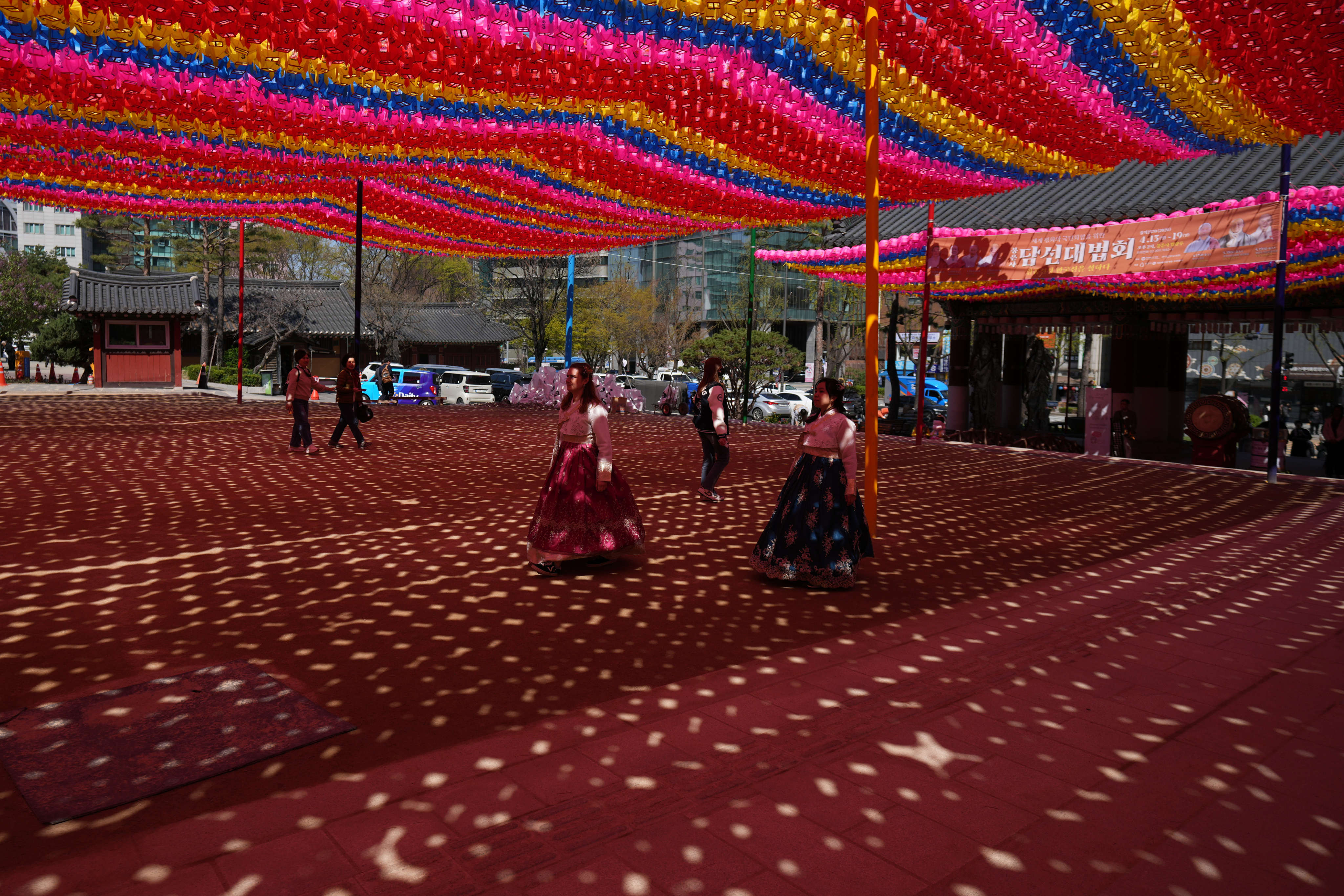 Foreigners dressed in hanboks walk under lanterns displayed at Jogye temple in Seoul, South Korea, on April 7. Photo: AP