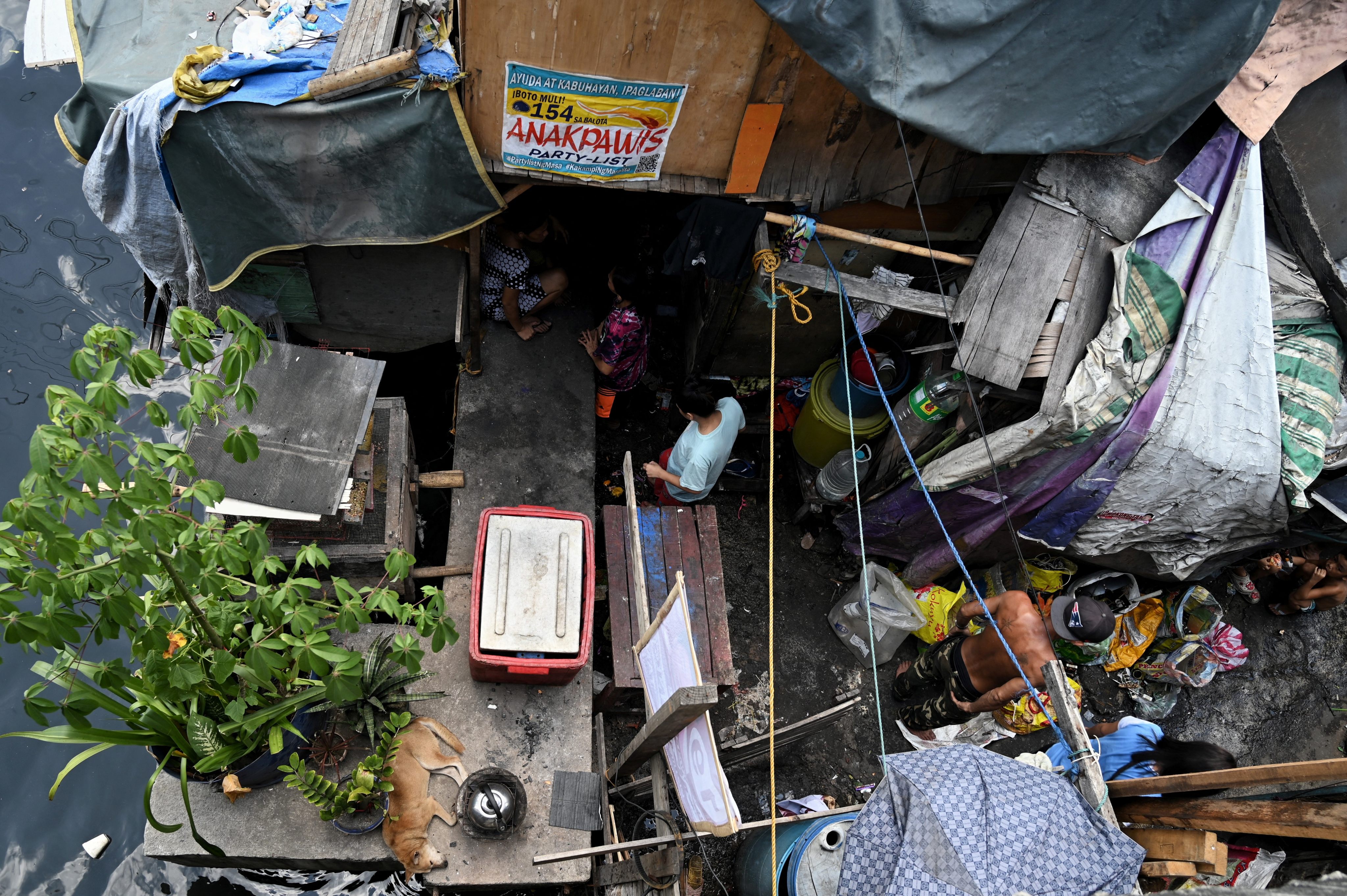 Residents of a slum in Manila stand inside their home. More than half a million people live in slums in the Philippines. Photo: AFP