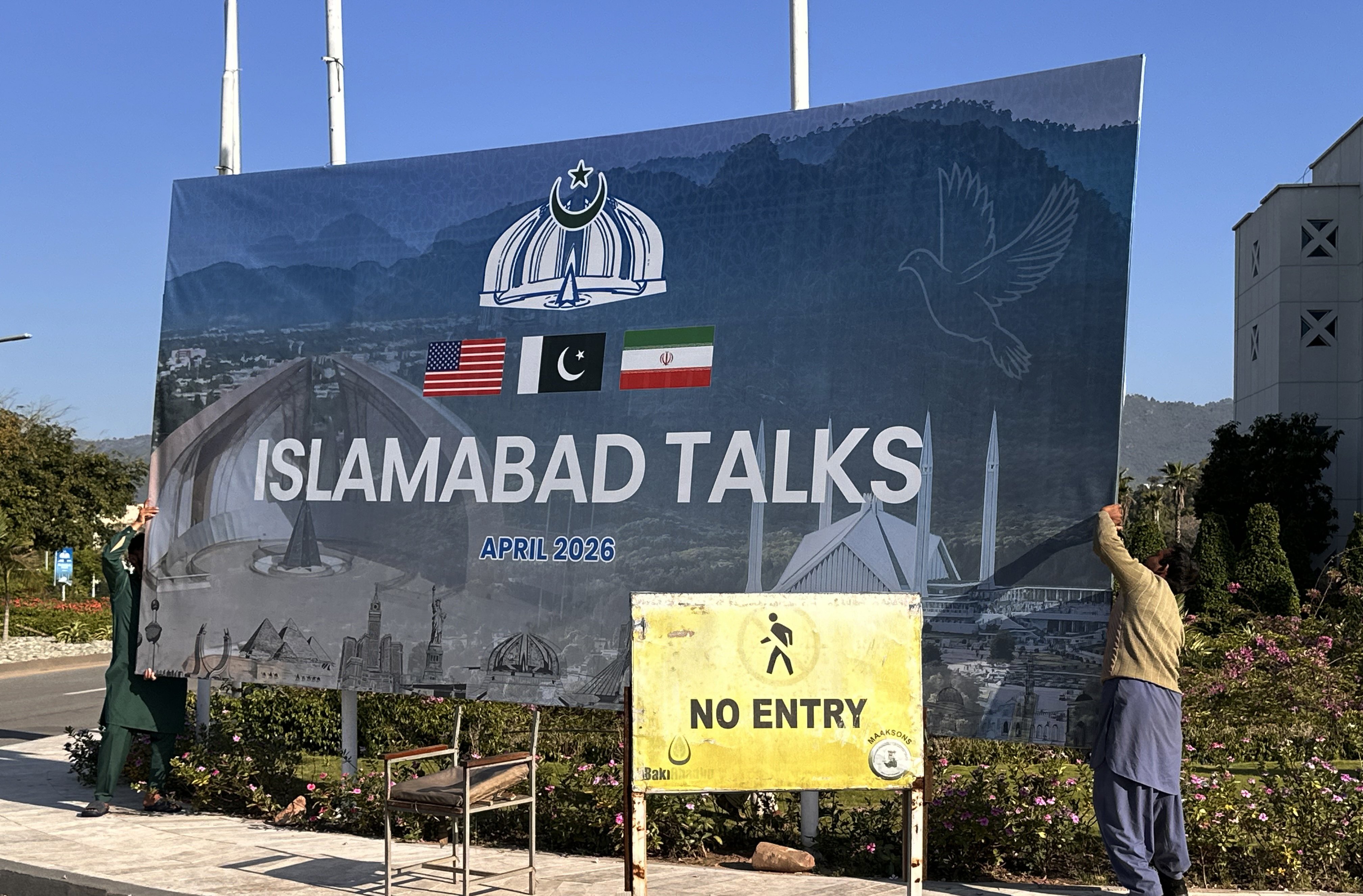 Workers remove a billboard after the failed peace talks between the United States and Iran, in Islamabad, Pakistan, on April 12. Photo: EPA
