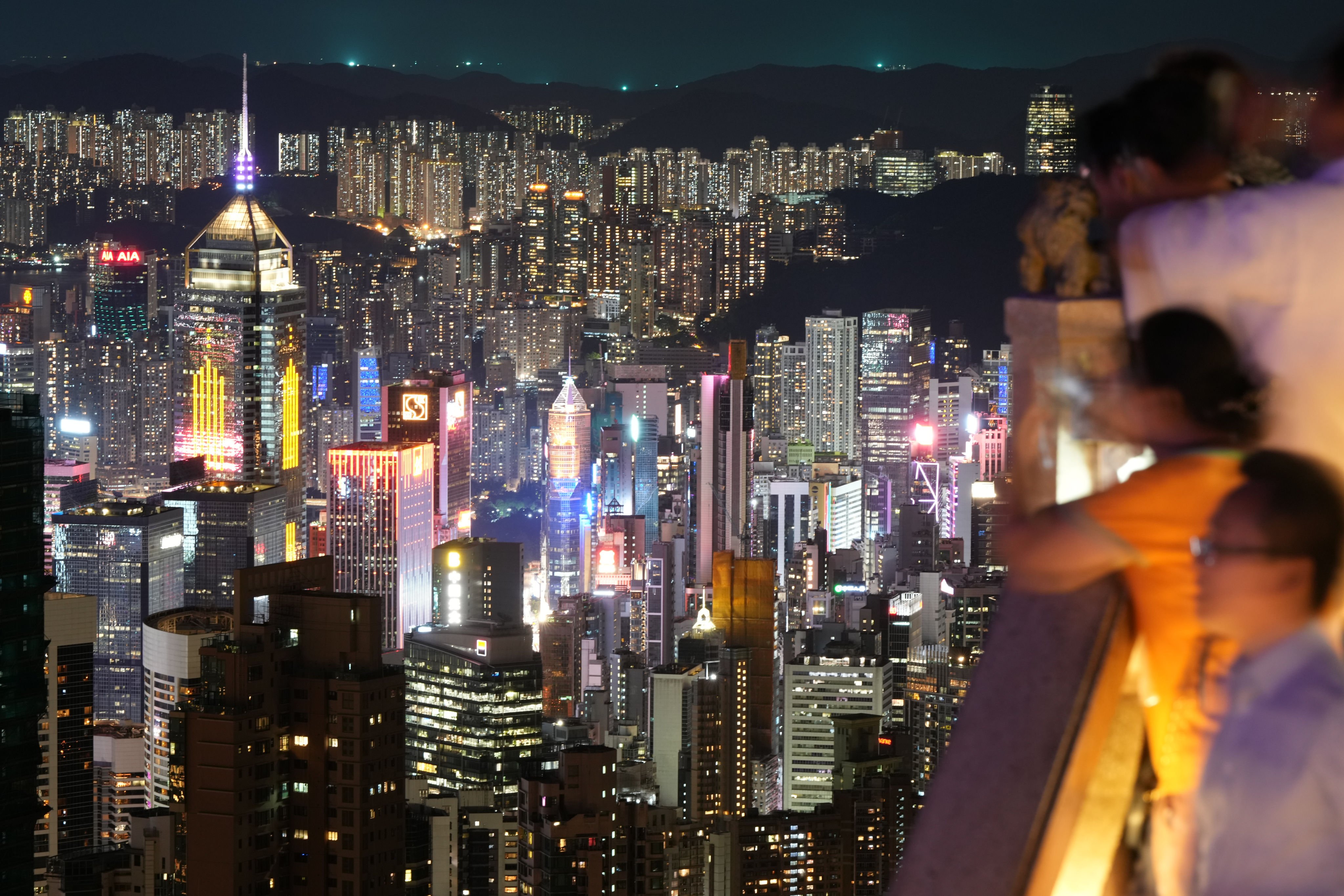 People take in the night view of Hong Kong Island from the The Peak in August 2025. Photo: Sam Tsang