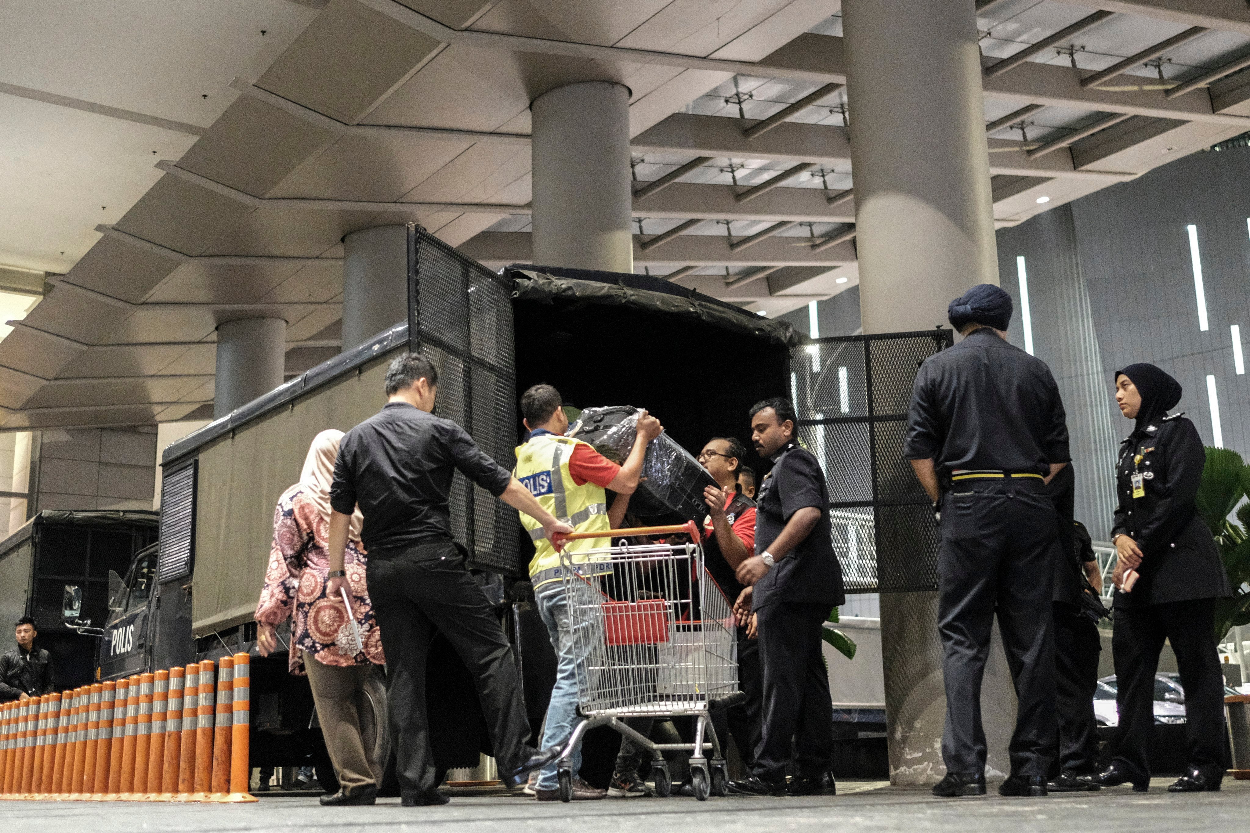 Boxes of seized goods taken from a Kuala Lumpur condominium owned by former Malaysian prime minister Najib Razak’s family are loaded into a police truck by officers in 2018. Photo: EPA-EFE
