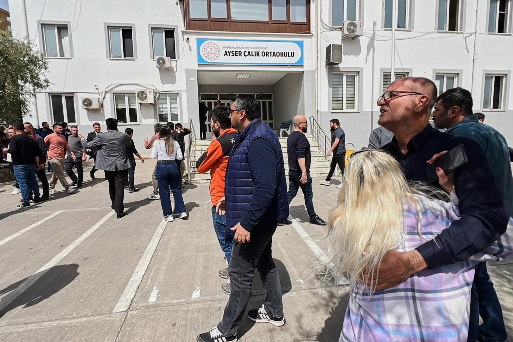 People stand at the courtyard of a secondary school where an assailant opened fire, in Kahramanmaras, Turkey, on Wednesday. Photo: IHA via AP