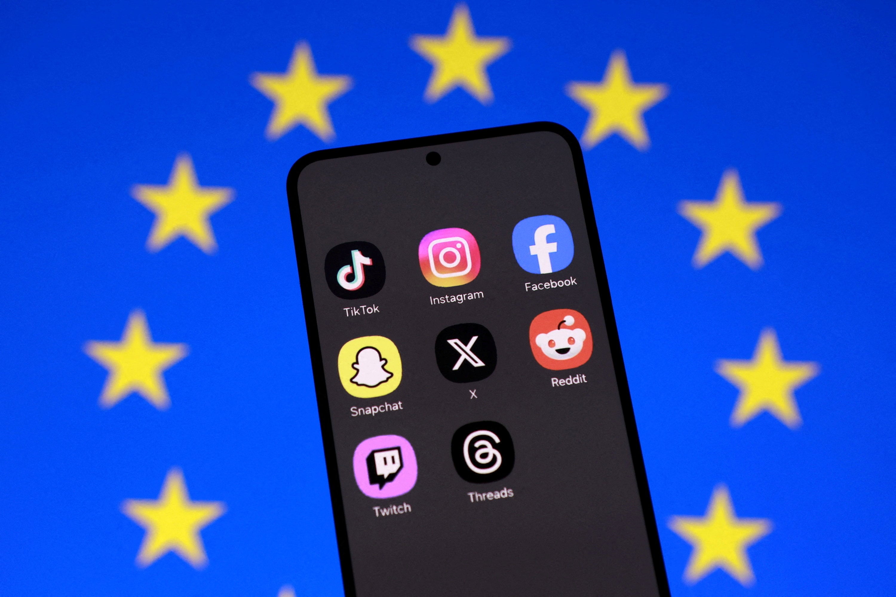 An illustration shows an EU flag and smartphone with social media app icons displayed. Photo: Reuters