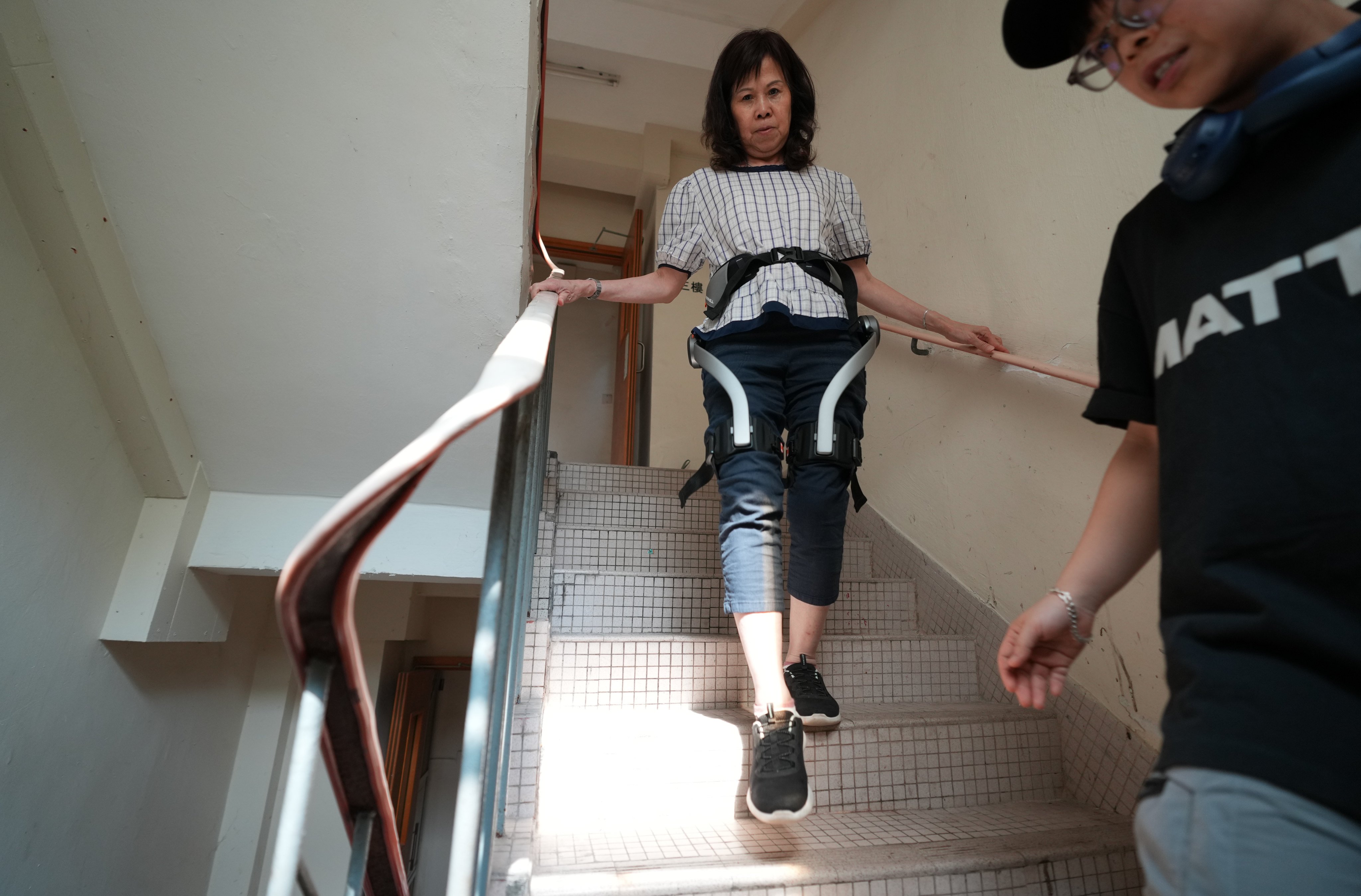 Mok Yin-fun, 69 years old, a resident of Wang Fuk Court, tries out the “Next-Gen Exoskeleton”, provided by Aid Vengers Federation, at Wang Fuk Living Room in Tai Po.
13APR26   SCMP/ Sam Tsang