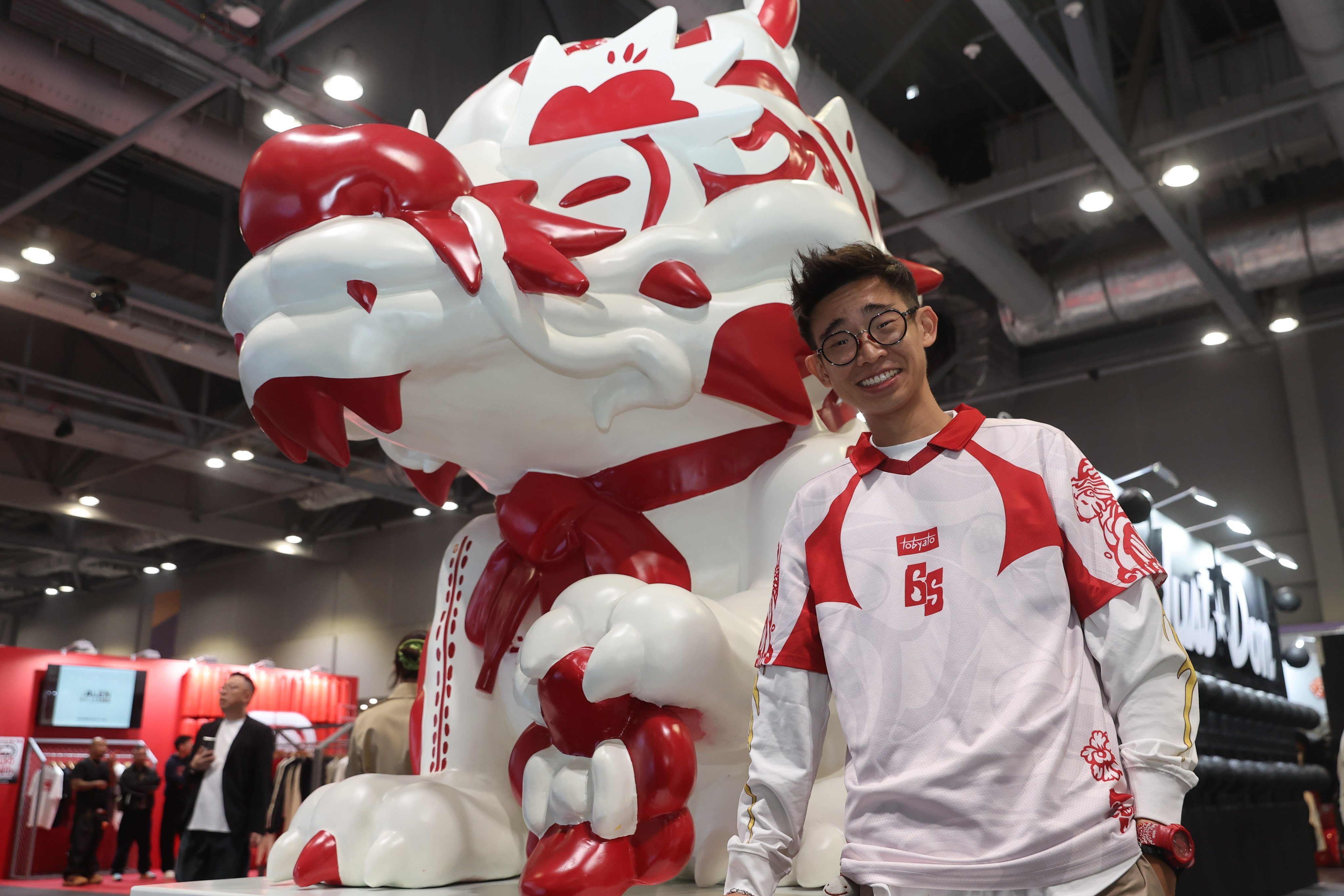 Singaporean visual artist Toby Tan, known as Tobyato, poses with his artwork, Sneaker Stone Dragon, at ComplexCon Hong Kong. Photo: Edmond So