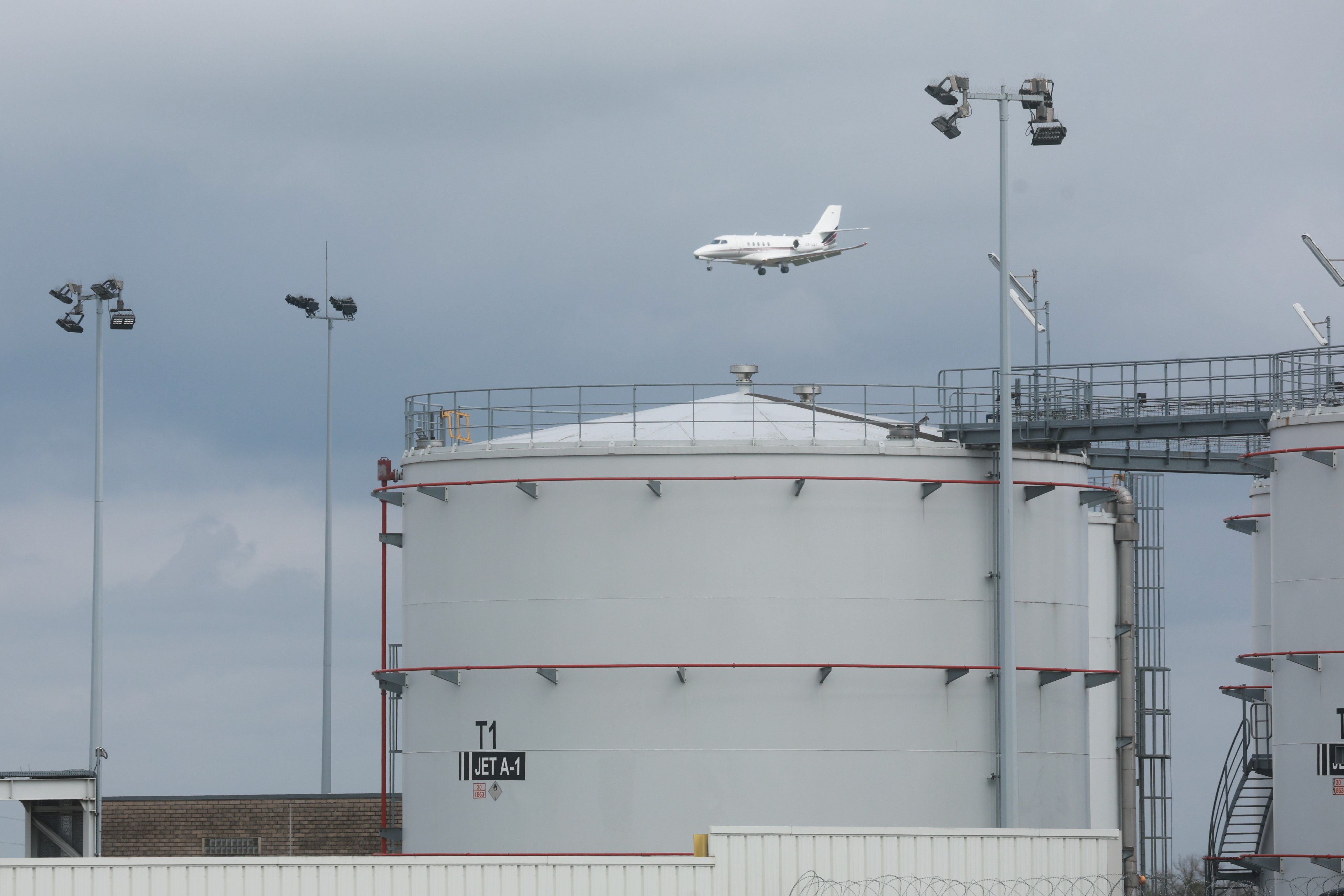 A plane passes behind kerosene storage facilities at Liege airport in Belgium on Thursday. Photo: EPA