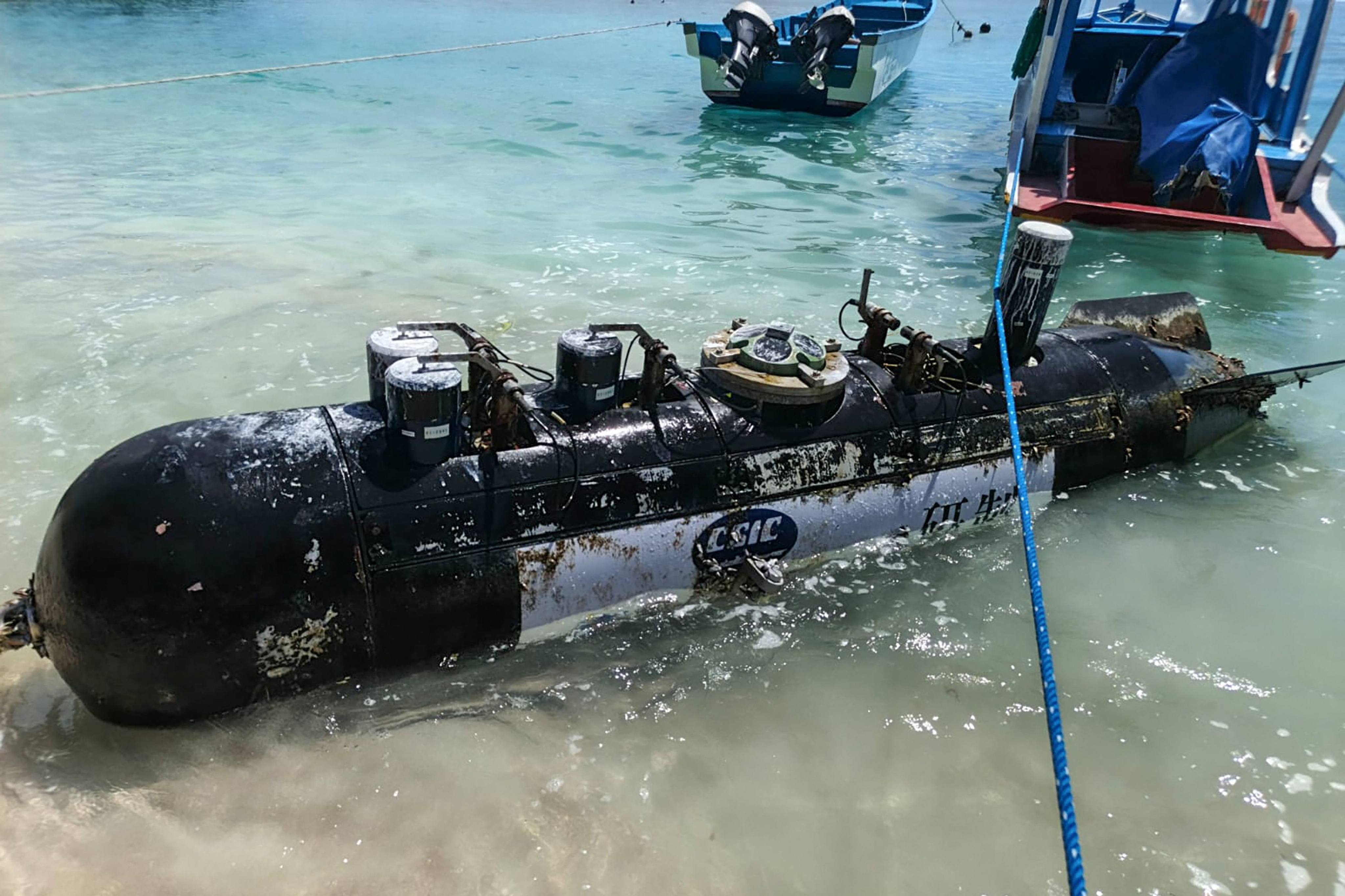 A torpedo-like object, discovered by a fisherman near the Lombok Strait, is towed ashore onto a beach on Gili Trawangan, West Nusa Tenggara, Indonesia, on April 6. Photo: AFP