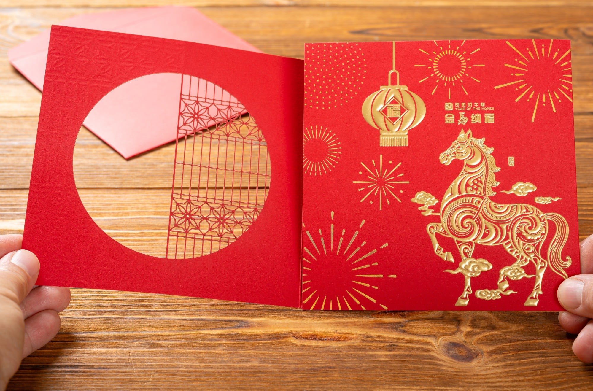 A man holds a modern-day 3D gift card with a horse on a red background. Photo: Shutterstock