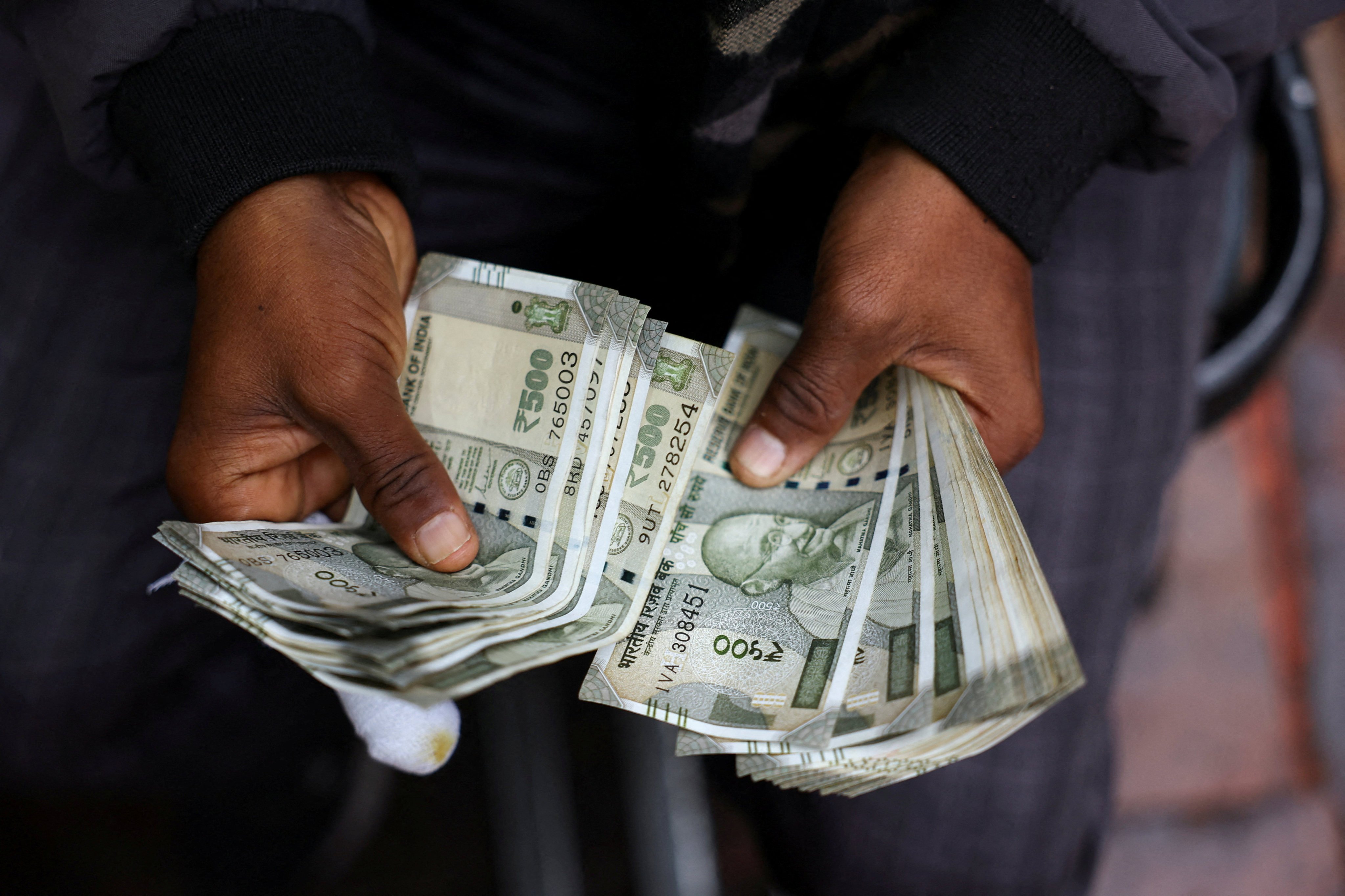 A man counts Indian rupee notes at a roadside currency exchange stall in the old quarters of Delhi on February 2. Photo: Reuters