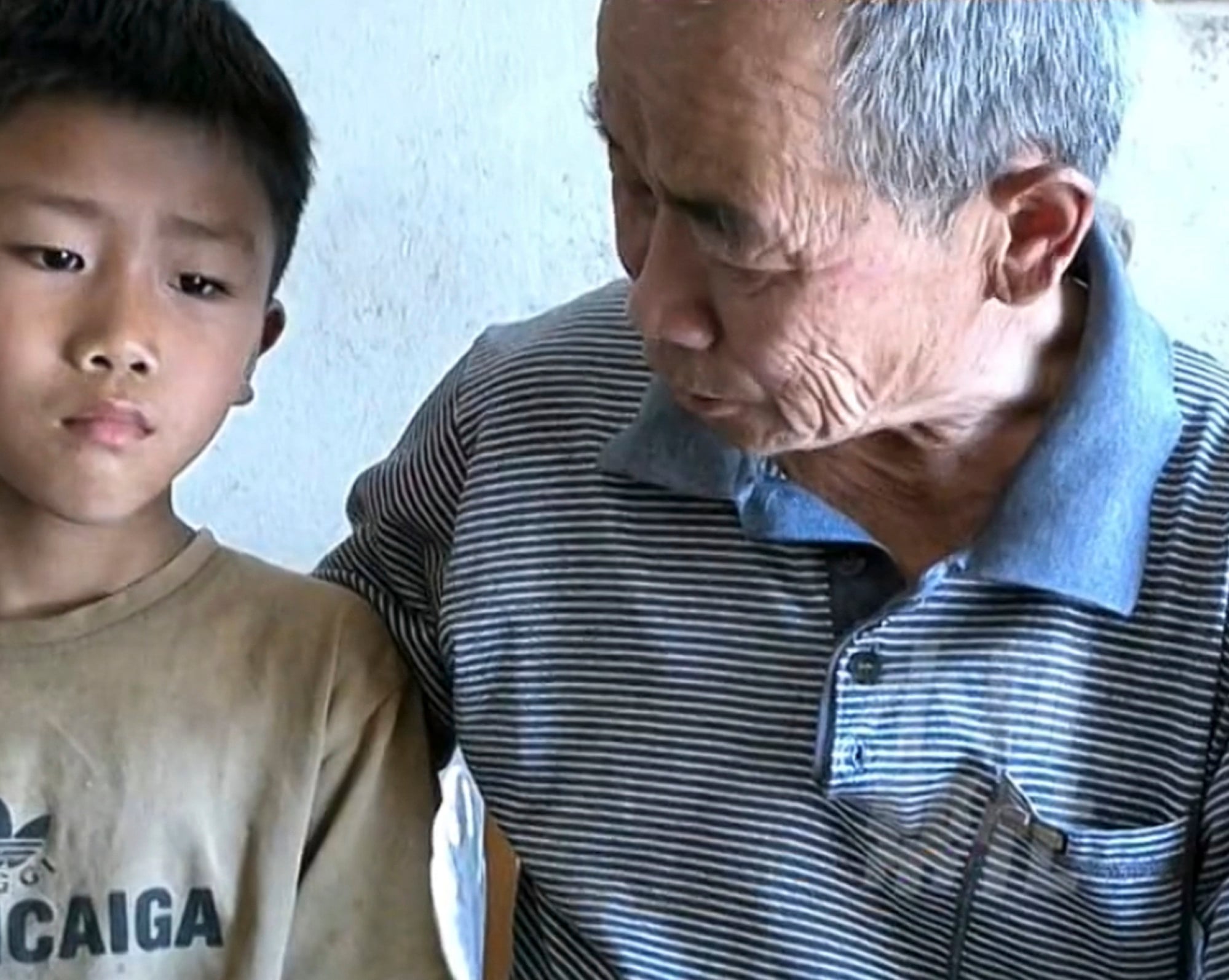 Zichen being comforted by his grandfather, the only family member left to look after him. Photo: Weibo