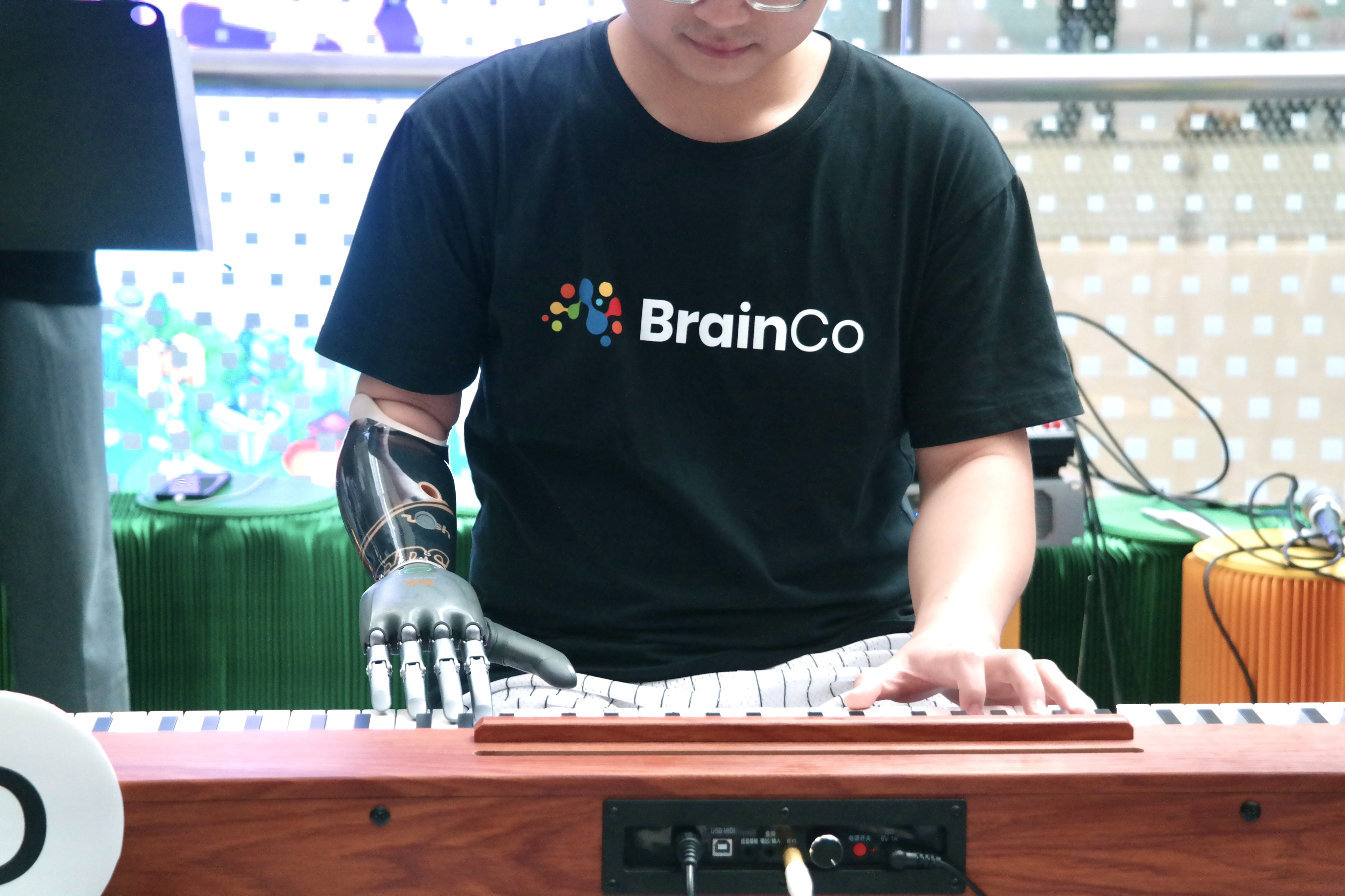 An amputee plays an electronic keyboard using BrainCo’s AI-powered mechanic arm at the World AI Conference in Shanghai on July 27, 2025. Photo: VCG via Getty Images