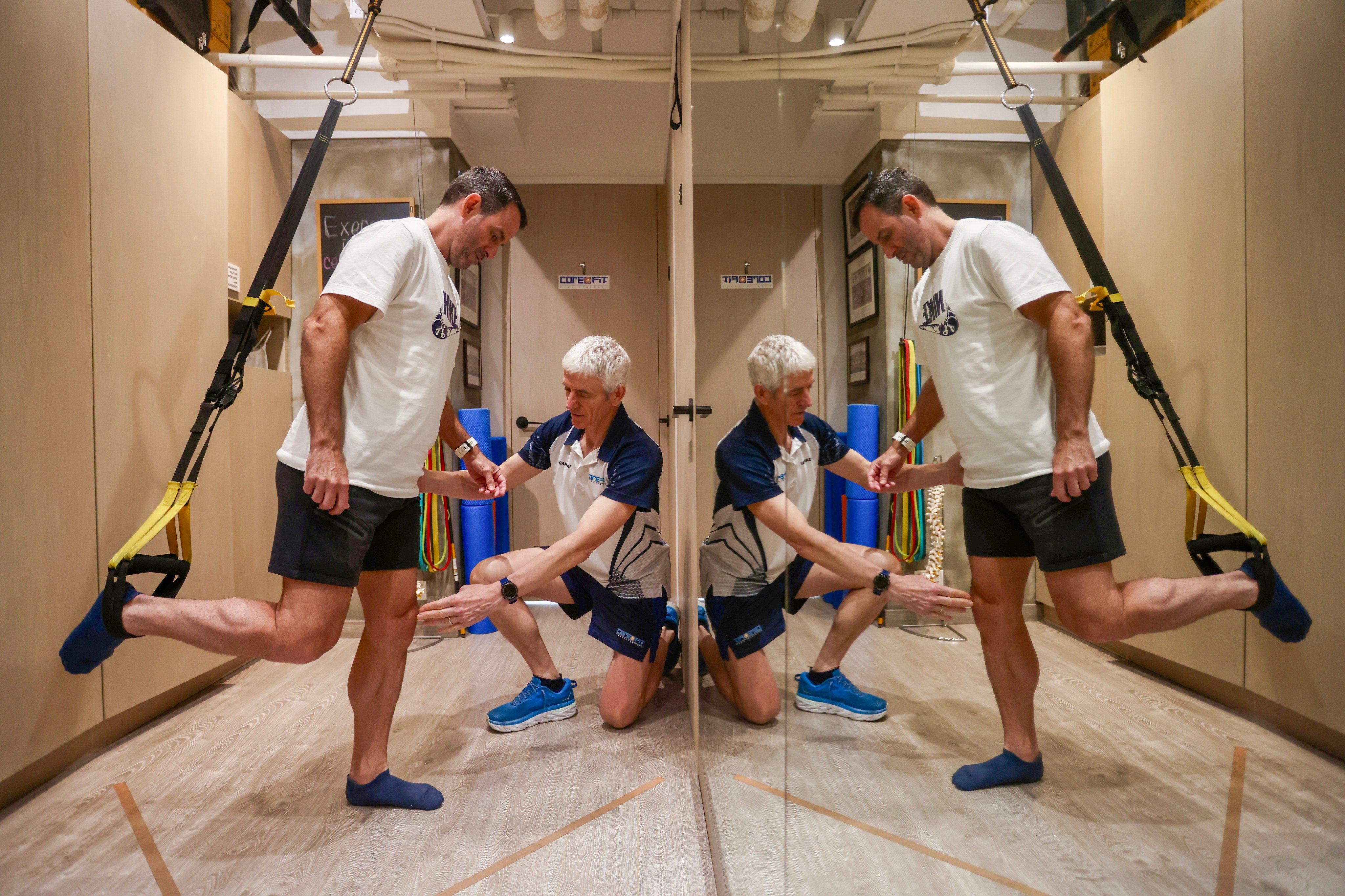 Tim McCosker (kneeling), a physiotherapist at CoreOFit Physio, works with his patient, former Hong Kong rugby player Rob Naylor, at the clinic in Causeway Bay. Photo: Jonathan Wong