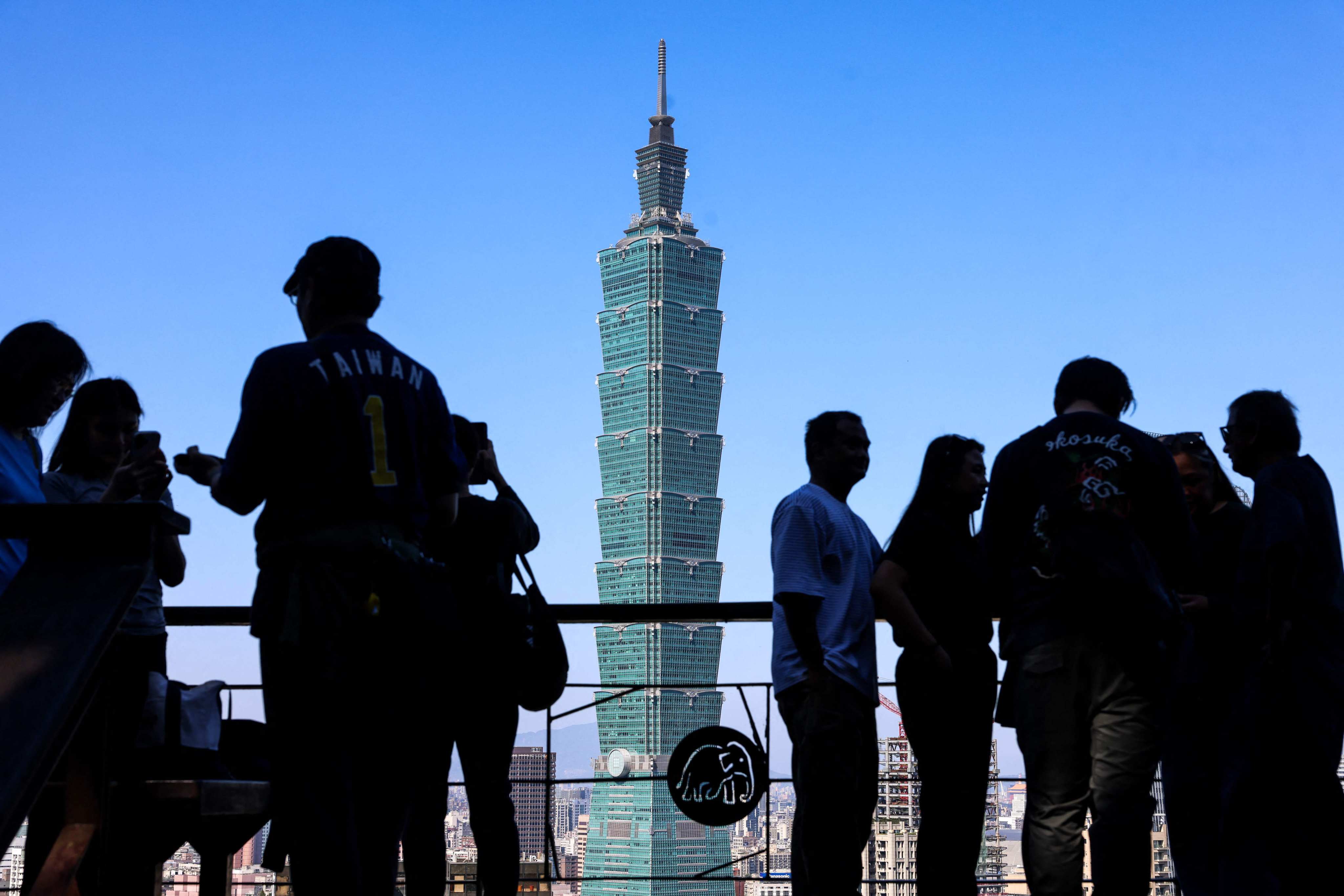 People gather at a lookout point, with the Taipei 101 skyscraper in the background, in Taipei on January 14. Beijing has proposed 10 cross-strait measures, including easing restrictions on individual travel to Taiwan. Photo: AFP