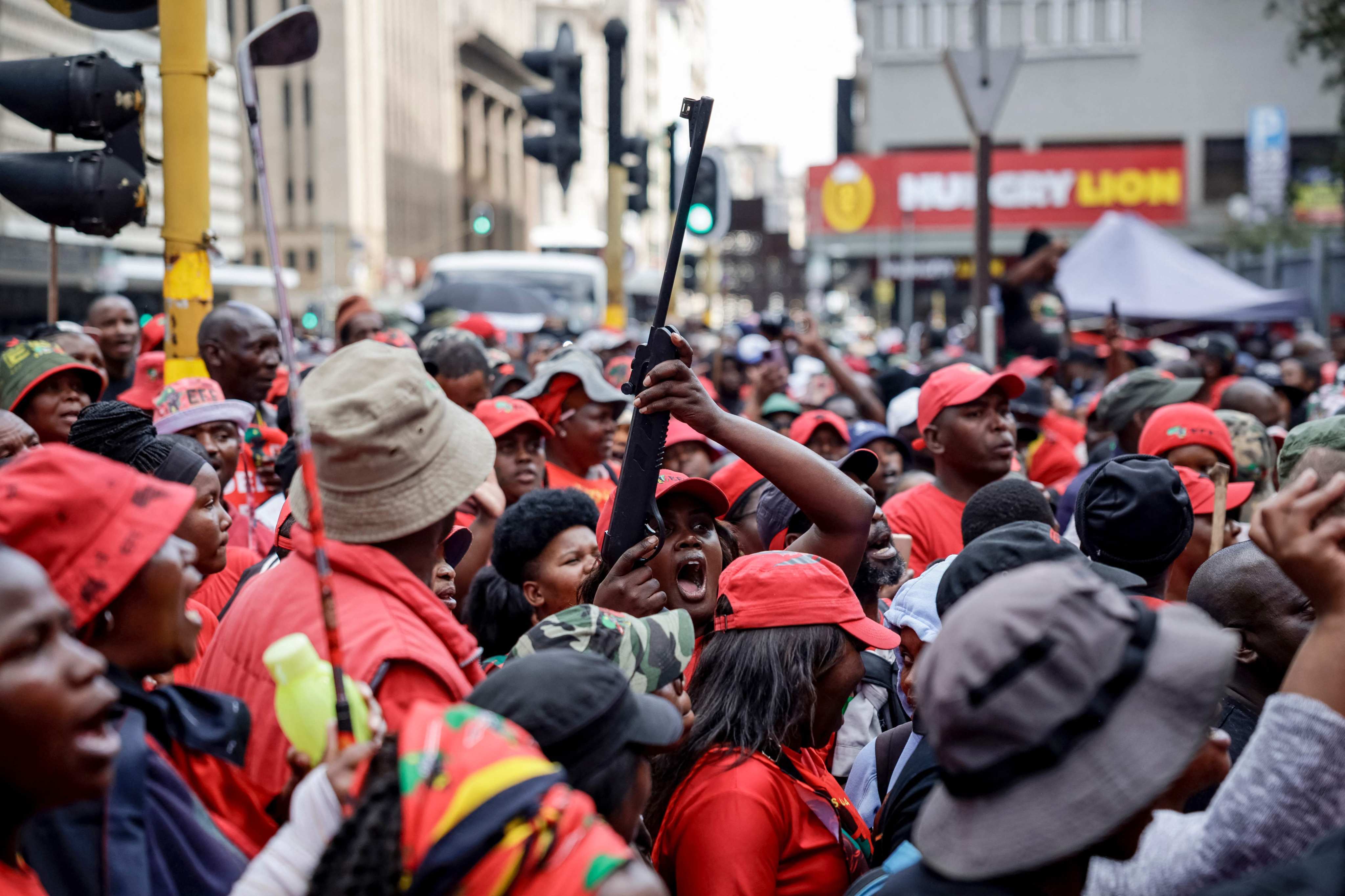 A supporter holds a mock gun while gathering with others in Johannesburg. Photo: AFP