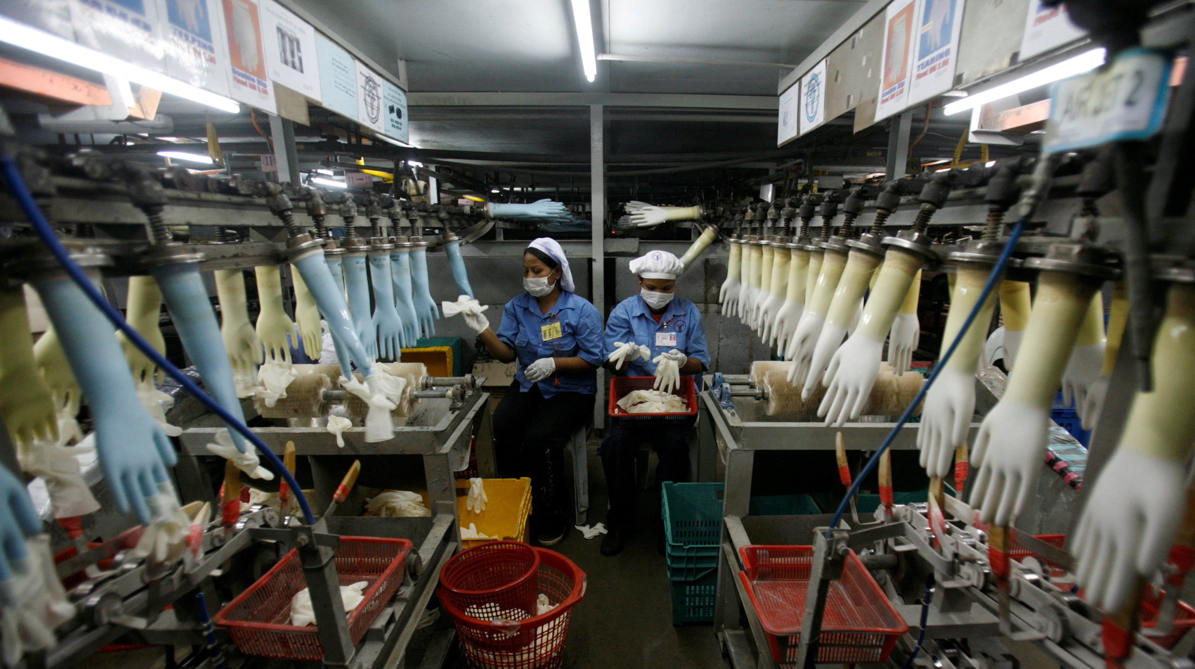 Workers collect rubber gloves at Top Glove’s factory in Klang, outside Kuala Lumpur. Photo: Reuters