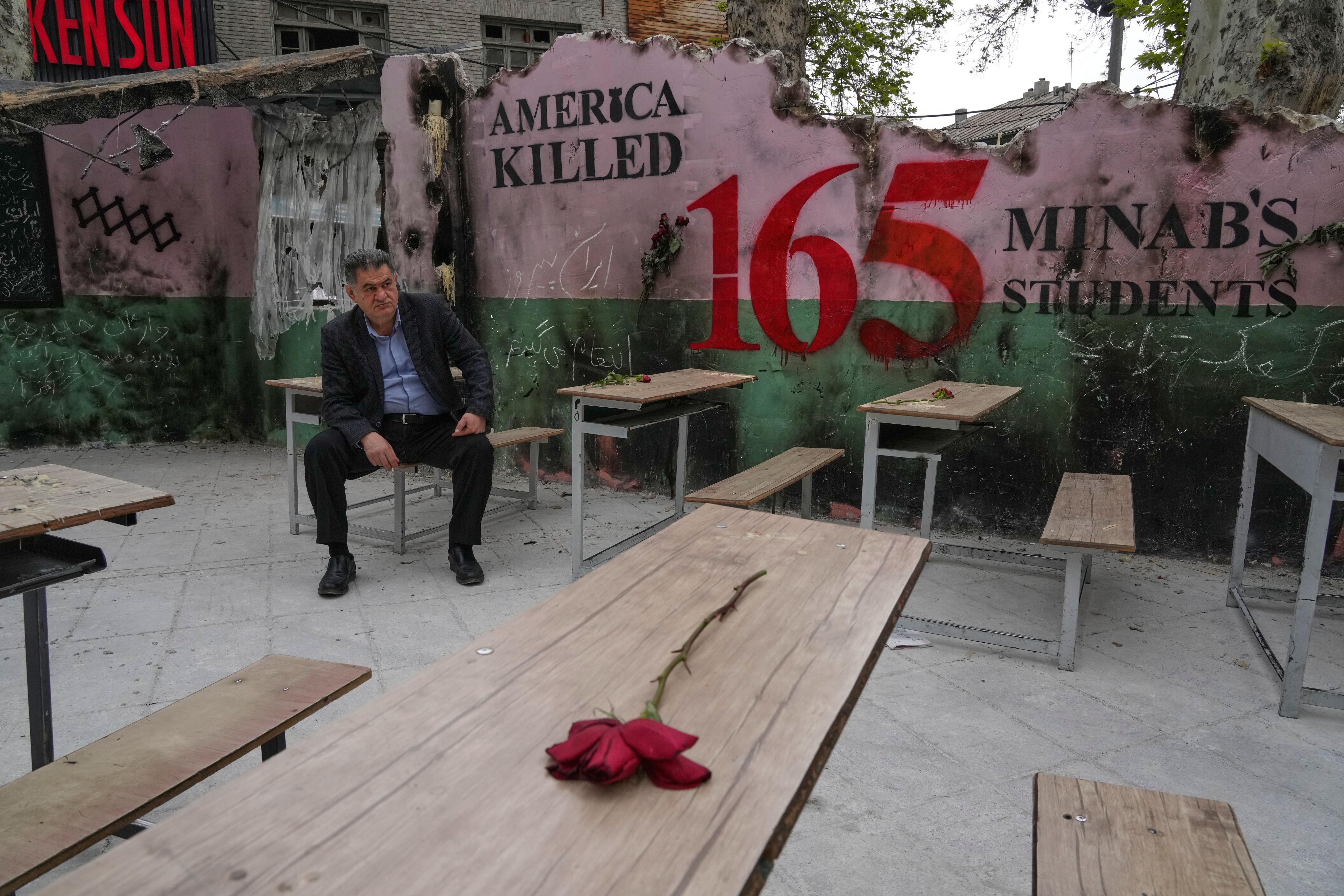 A man sits on a bench in a memorial, set for the students  who were killed during a February 28 strike on a school in southern town of Minab, on April 12. Photo: AP