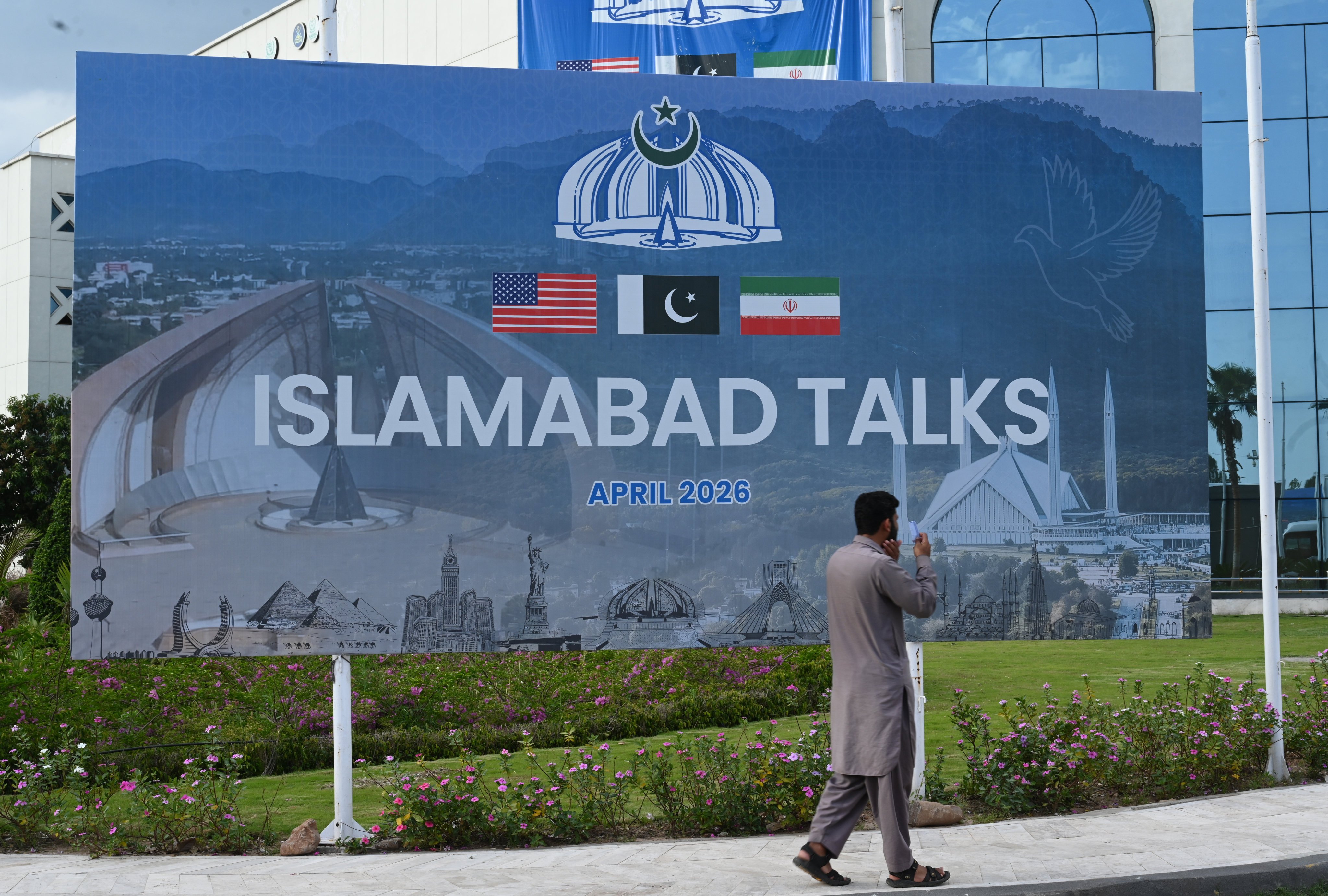 A pedestrian passes a billboard for the US-Iran talks in Islamabad, Pakistan, on April 11. Photo: Xinhua