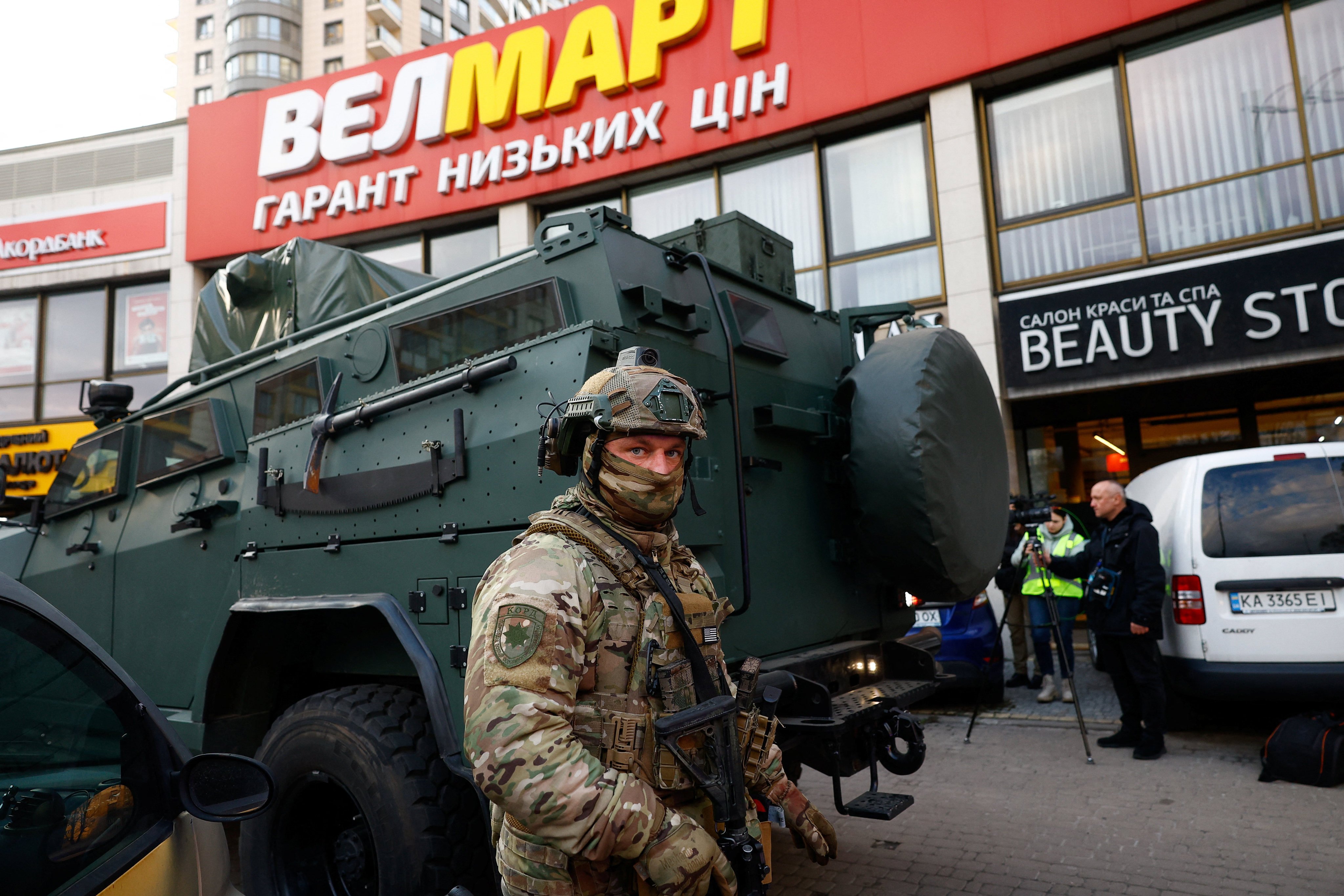 A Rapid Operational Response Unit member stands by an armoured vehicle outside a supermarket where the gunman barricaded himself in Kyiv on Saturday. Photo: Reuters