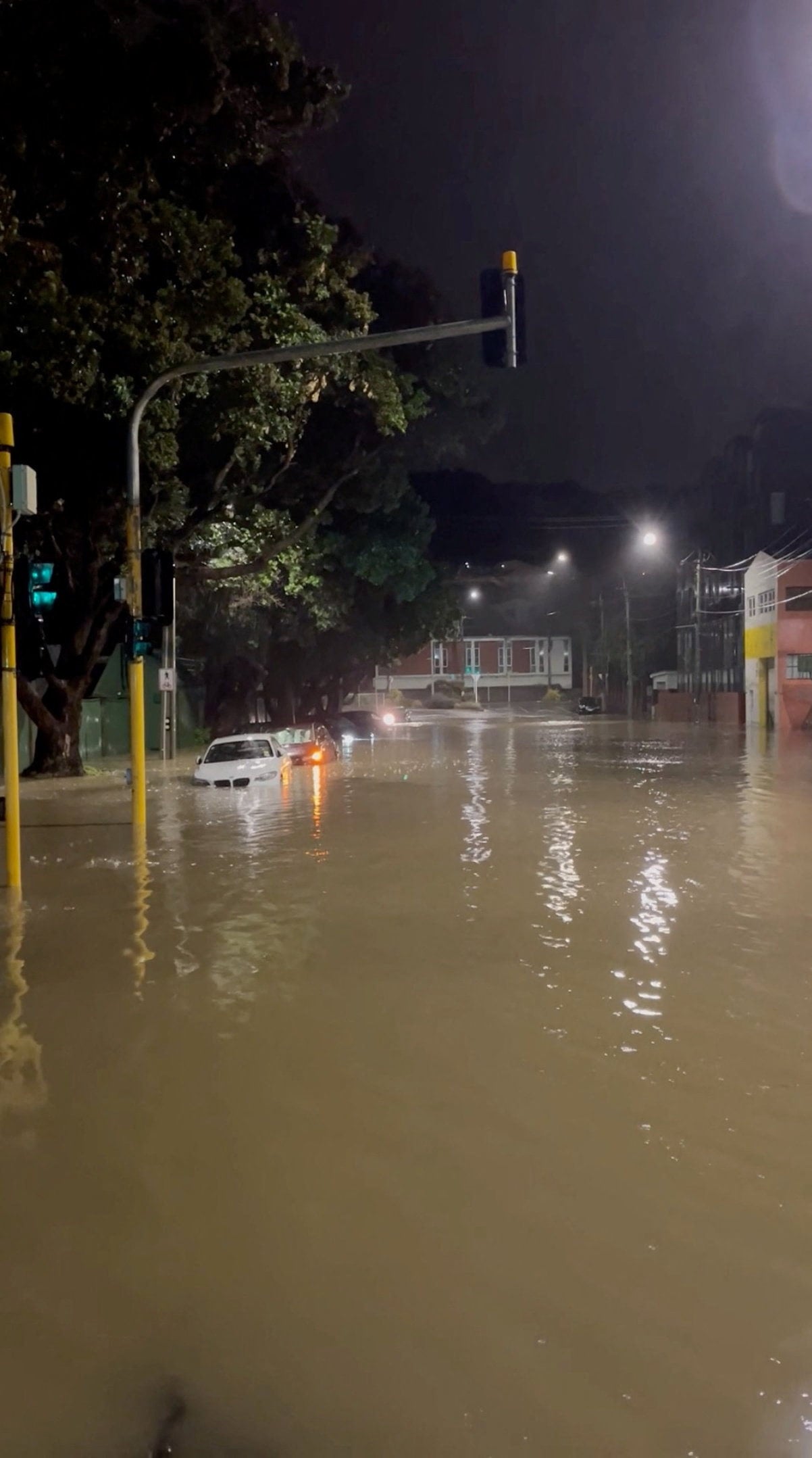 Vehicles can be seen partially submerged along a flooded road in Wellington, New Zealand, in a screengrab taken from a social media video on Monday, . Photo: Reuters