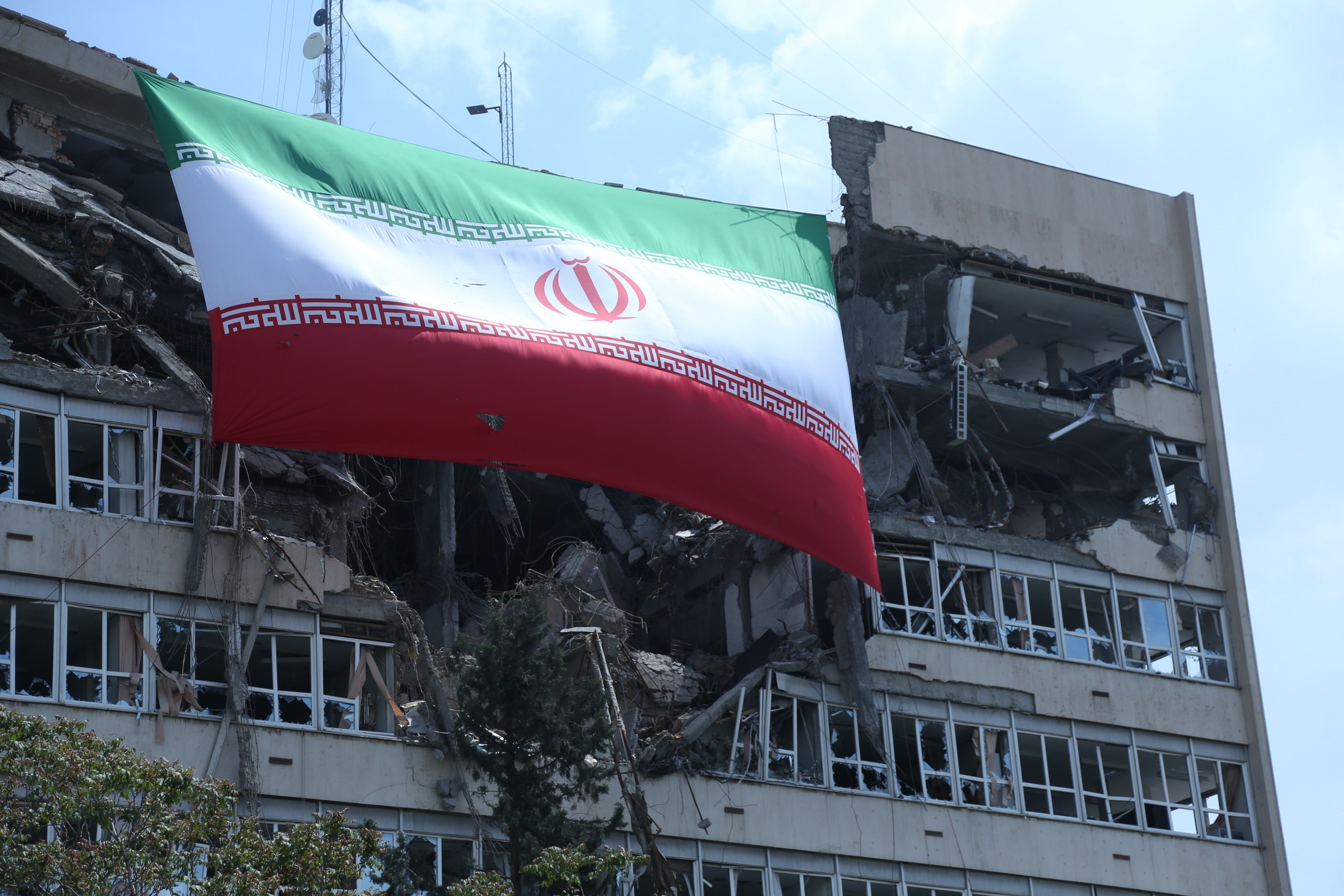 A national flag of Iran hangs from a building in Tehran that was damaged by US-Israeli attacks. Photo: Xinhua
