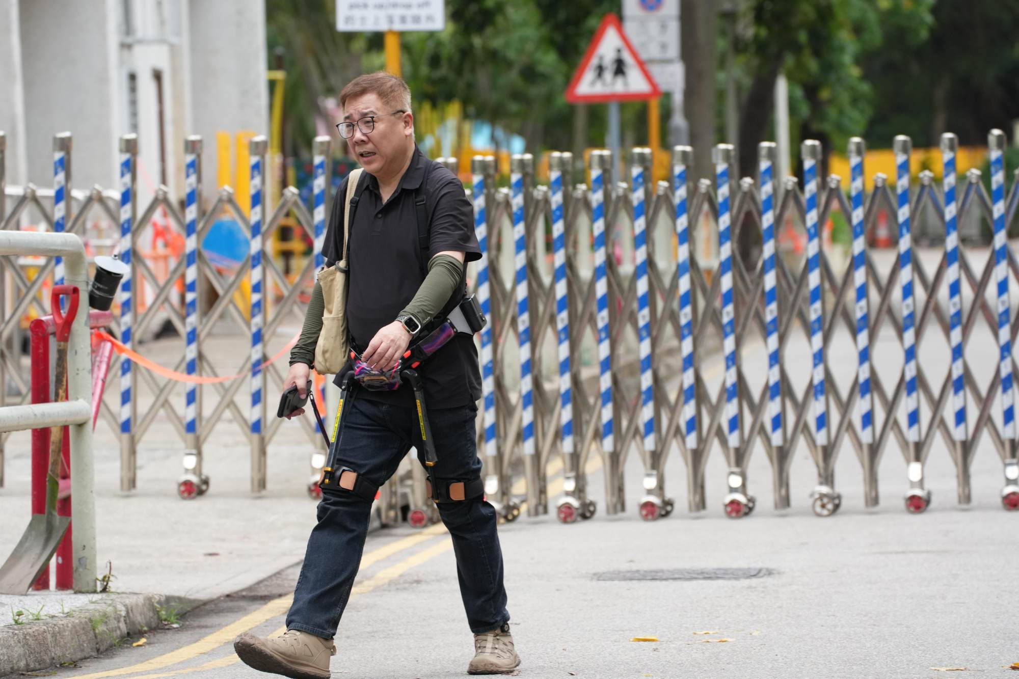 Resident Tam, 55, used an exoskeleton to aid his climb up to his 17th floor flat. Photo: Jelly Tse