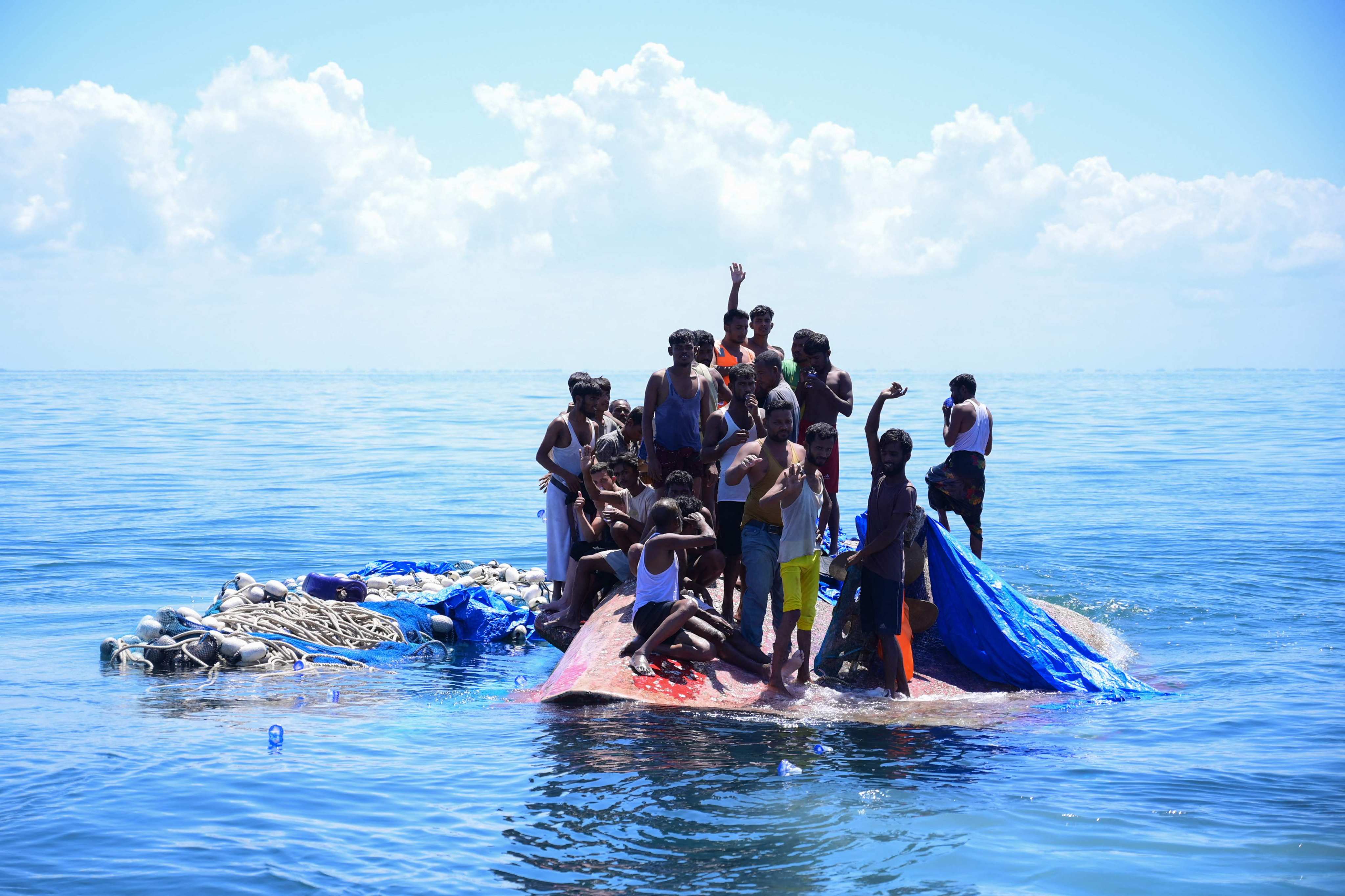 Rohingya refugees wait to be rescued from the hull of their capsized boat in waters off west Aceh in 2024. Photo: AFP