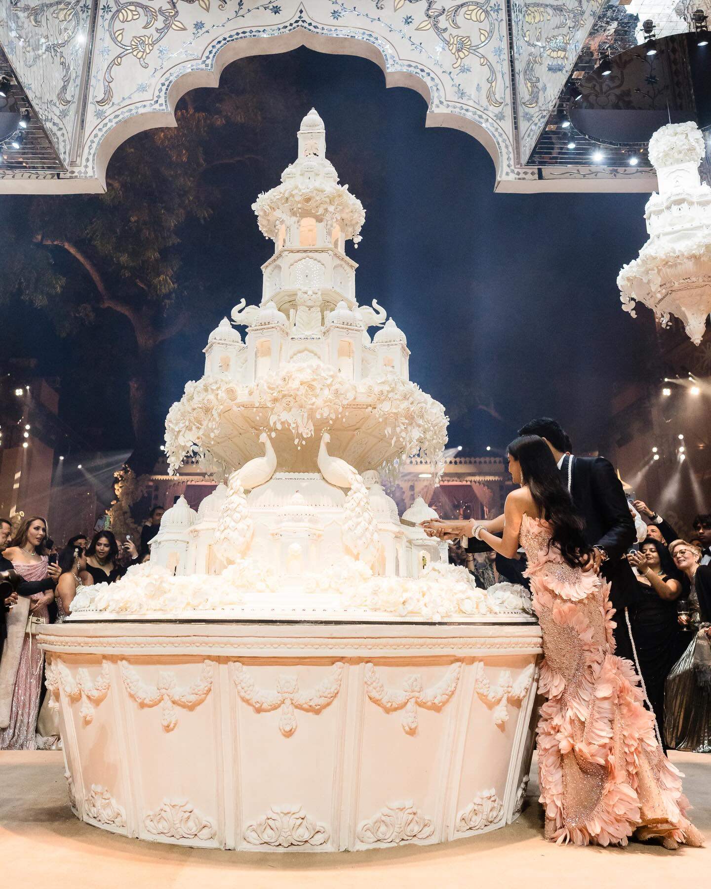 Netra Mantena and Vamsi Gadiraju on their wedding day with the Bastien Blanc-Tailleur designed cake. Photo: Instagram/thejoee