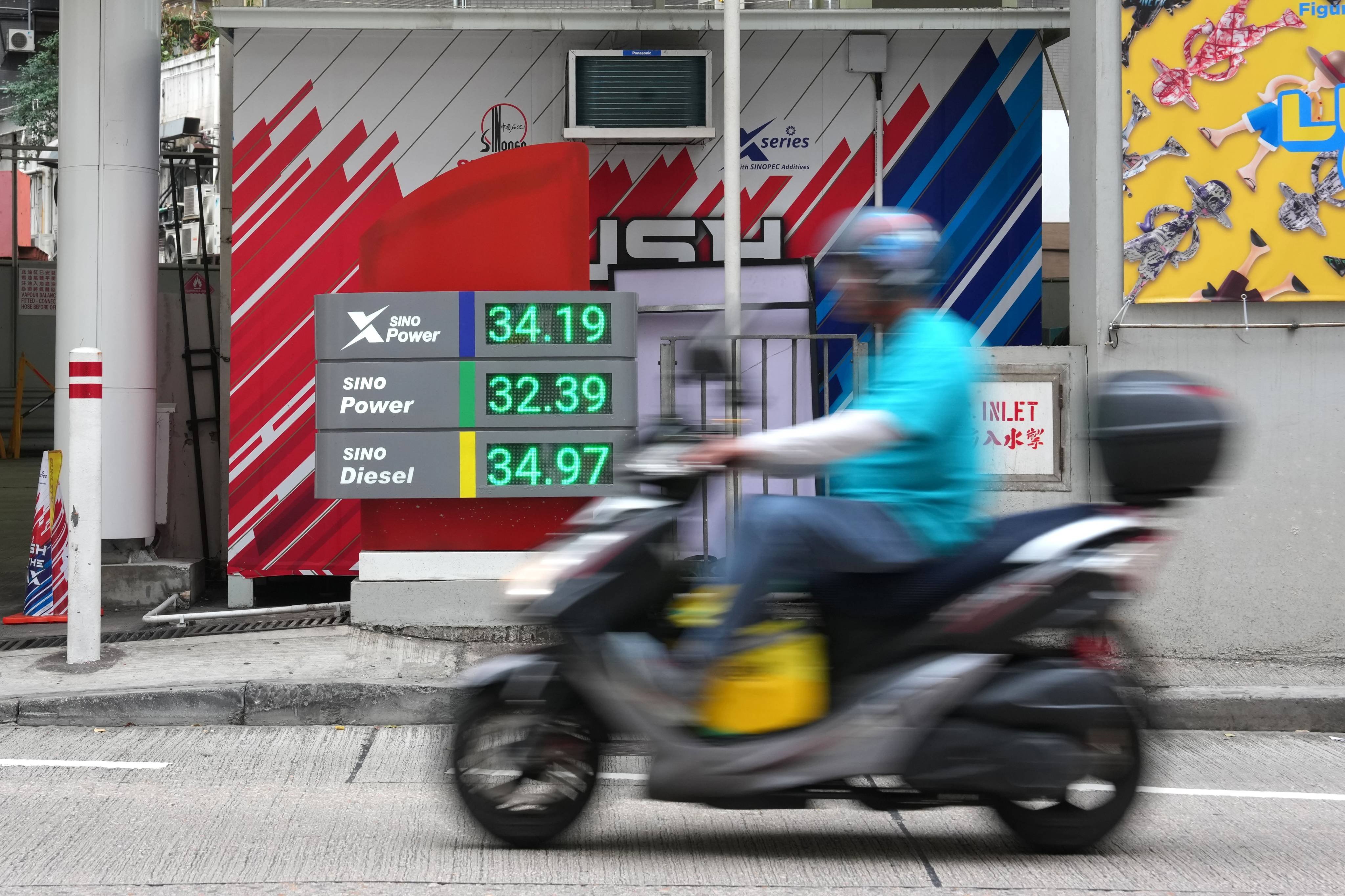 A motorcyclist rides by a price board at a petrol station in Causeway Bay on April 10. Photo: Jelly Tse