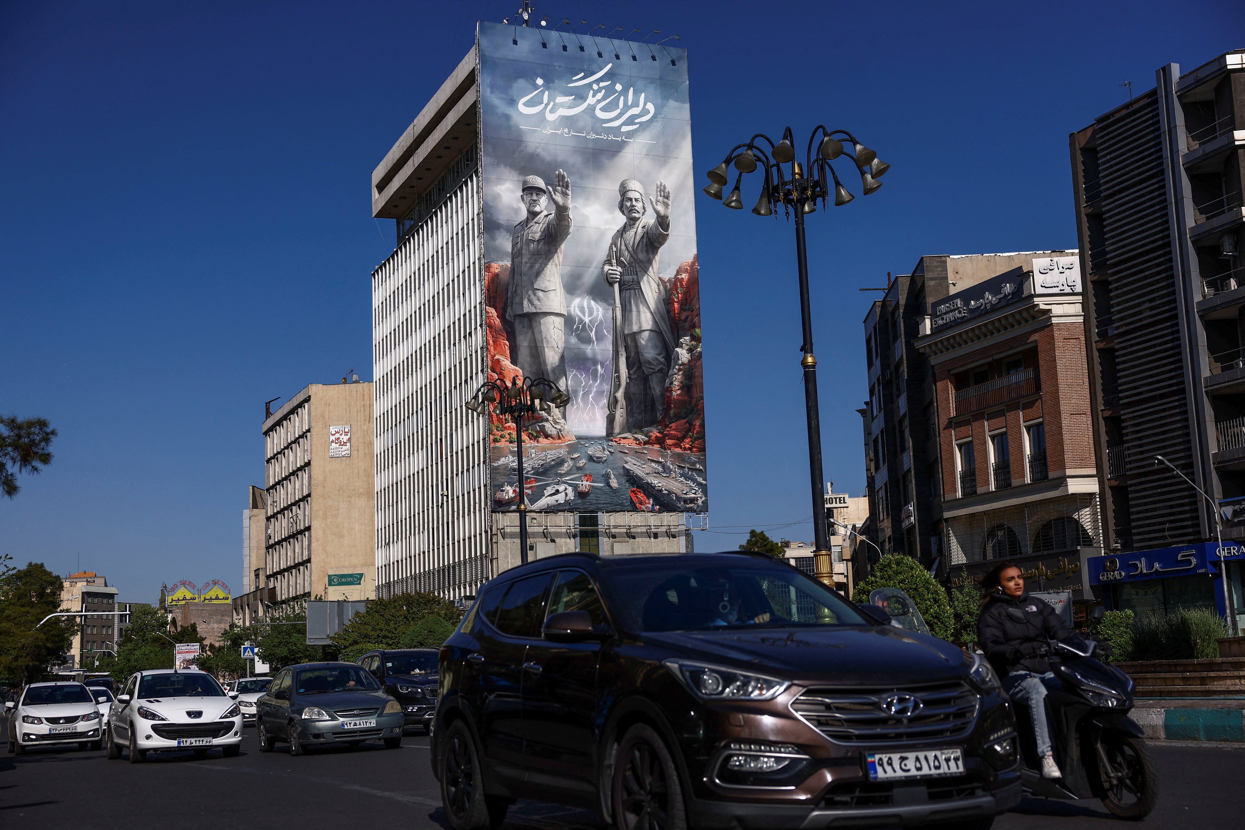 Commuters drive past a giant billboard referring to the Strait of Hormuz along a busy street in Tehran on Wednesday. Photo: WANA via Reuters