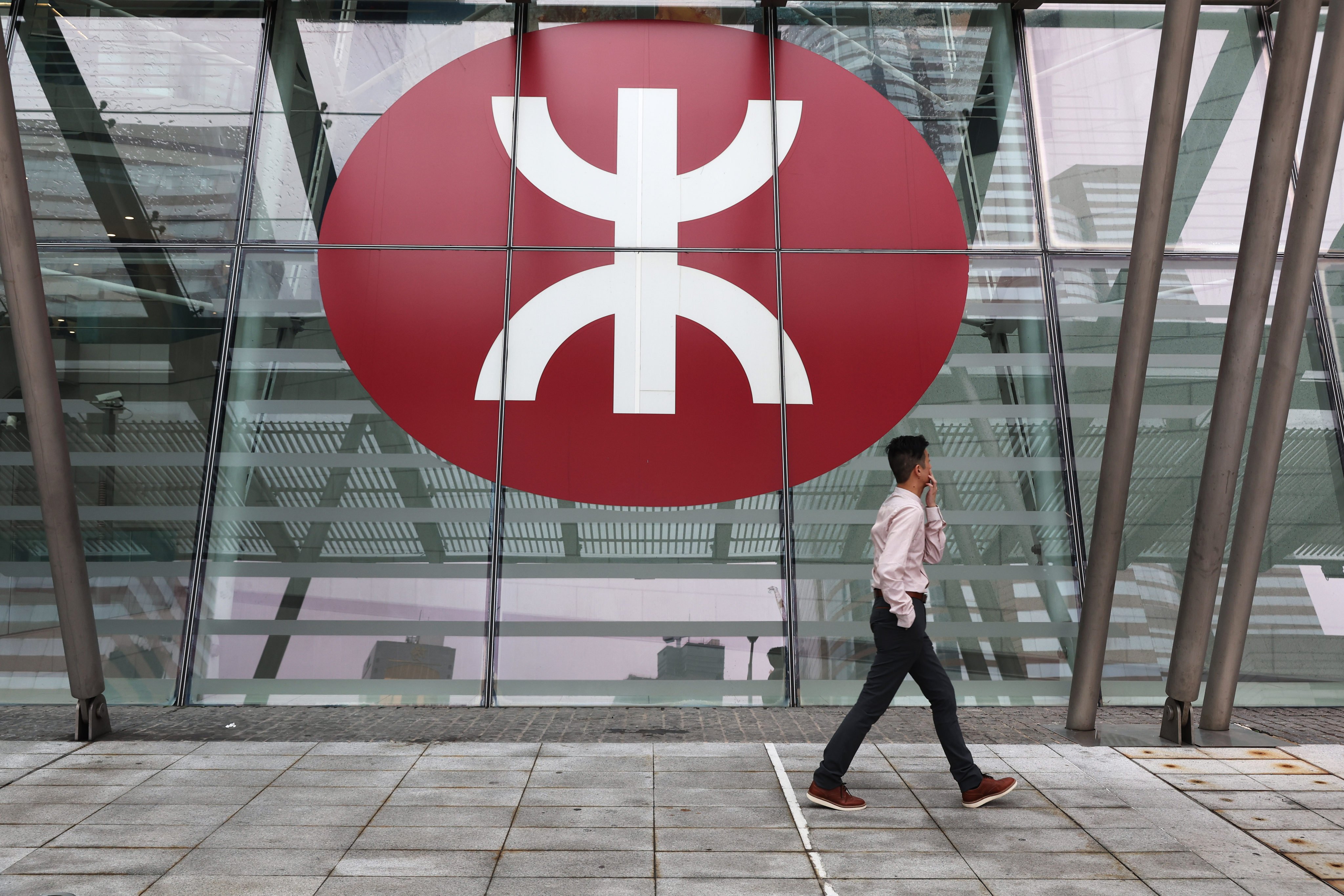 A man walks past the MTR logo outside the IFC building in Central. Photo: Edmond So