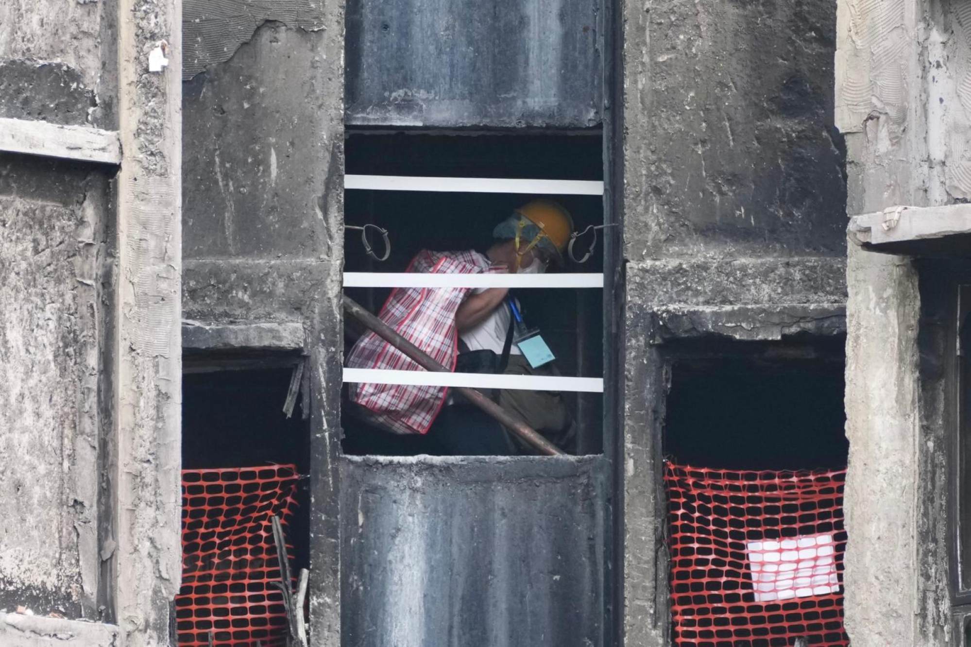 A Wang Sun House resident searches the remains of his flat on Friday. Photo: Karma Lo