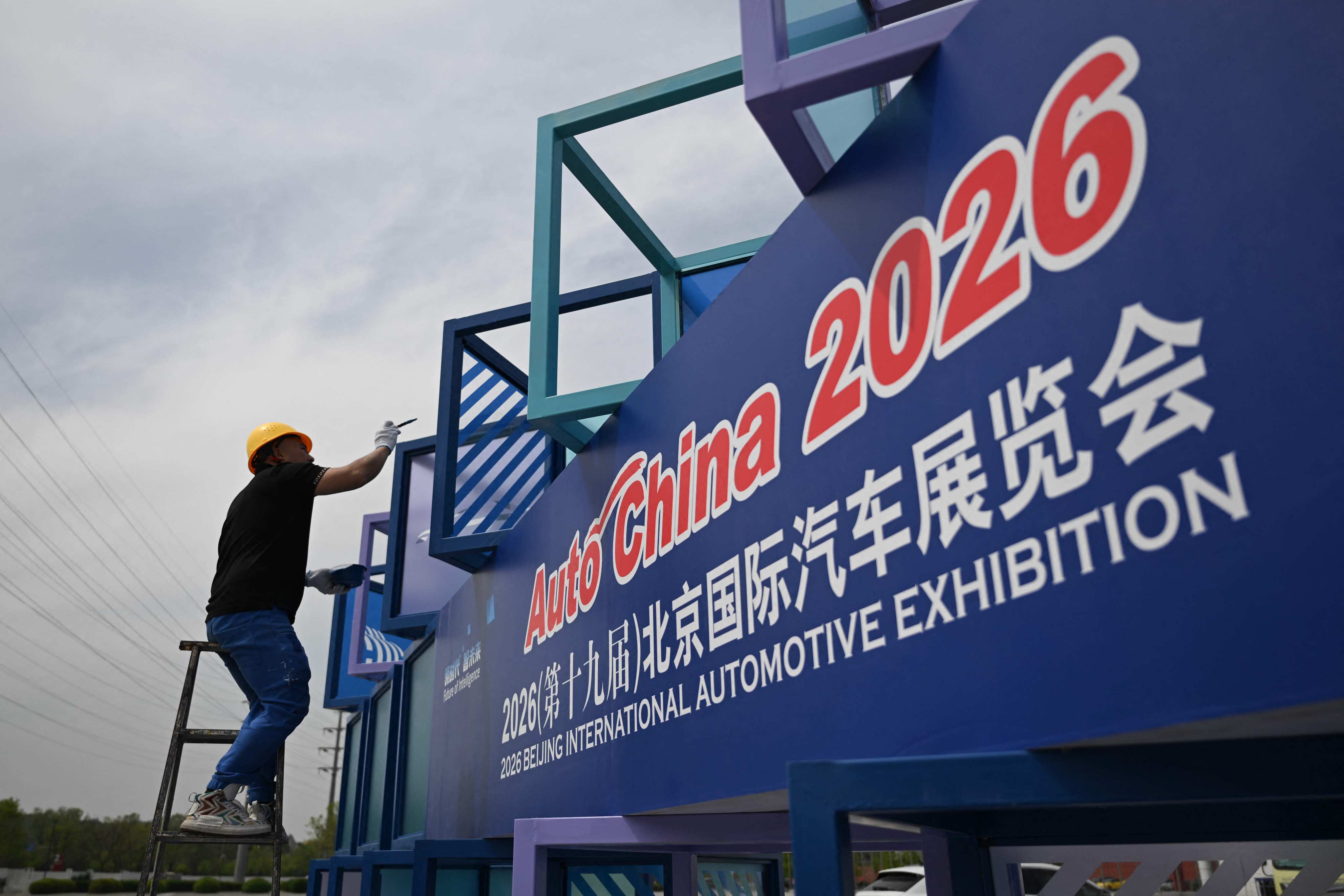 A worker puts the finishing touches on the China International Exhibition Centre in Beijing on Wednesday ahead of Auto China 2026. Photo: AFP