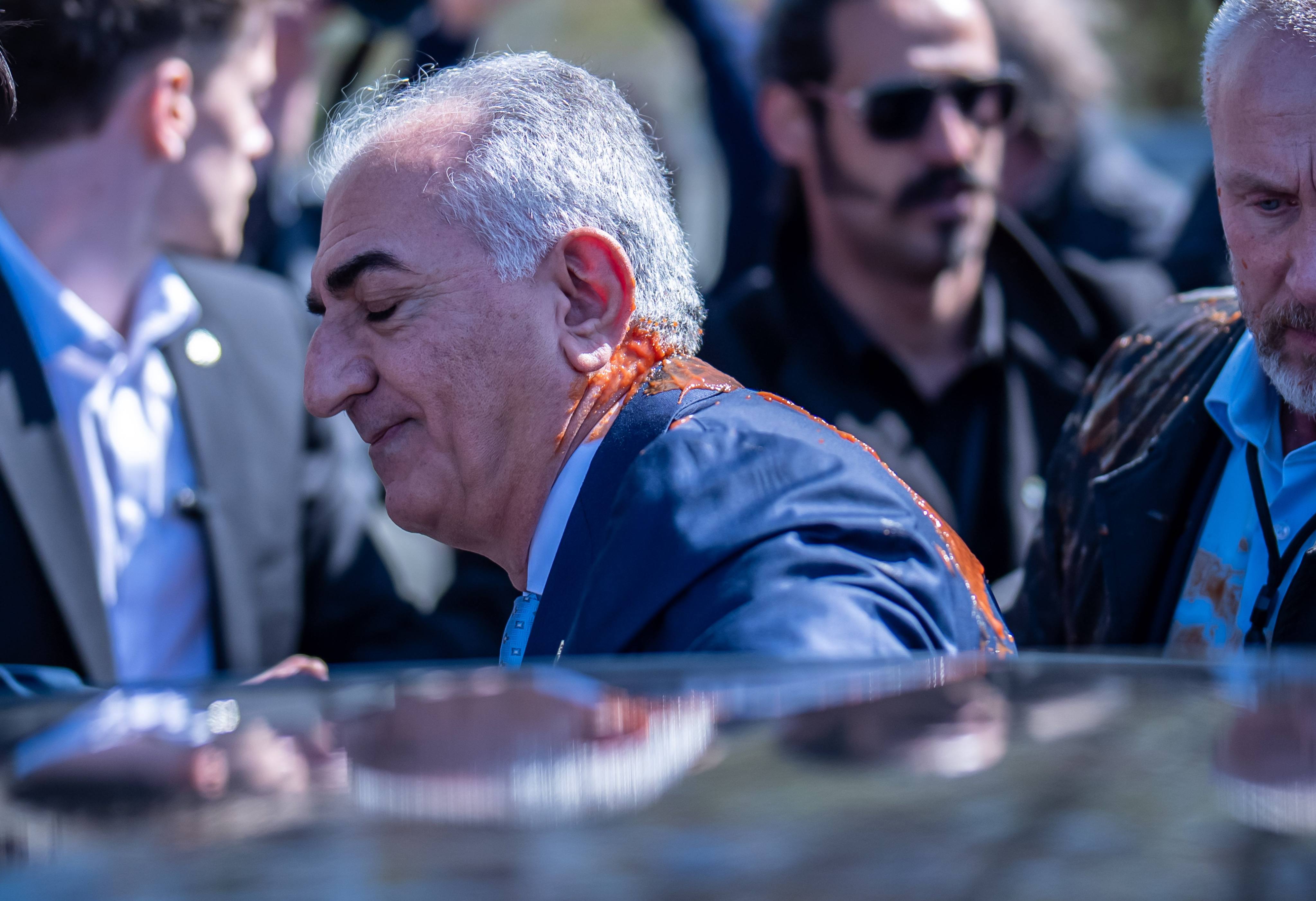Reza Pahlavi after he was splattered with that appears to be tomato juice or sauce. Photo: dpa